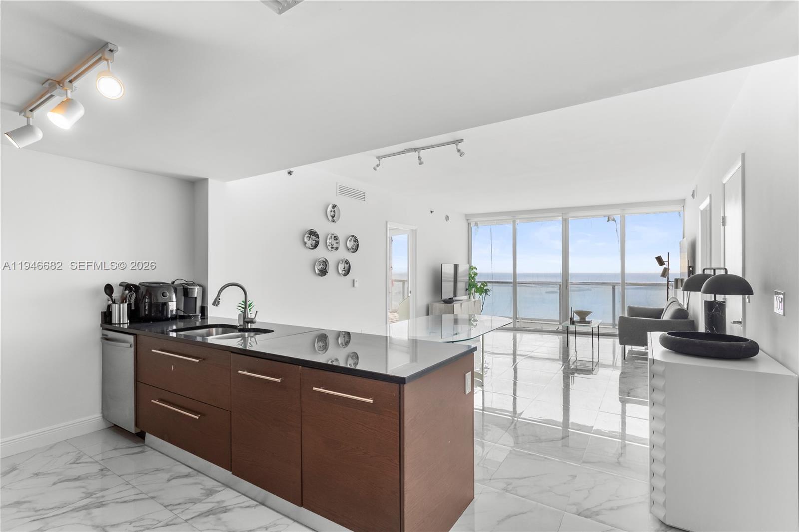Breathtaking 16-foot ceilings define this expansive 2-bedroom, 2-bath residence with a den, offering panoramic views of Biscayne Bay and the iconic Brickell Pool. The gourmet kitchen is outfitted with premium Sub-Zero, Wolf, and Bosch appliances, creating an ideal space for both everyday living and entertaining. Enjoy world-class, 5-star amenities at the W Hotel, including a state-of-the-art fitness center with complimentary classes, an infinity-edge pool with full towel service, a luxury spa, and renowned on-site dining such as Cipriani and Cantina Viente. Ideally located within walking distance to Brickell City Centre, top-tier restaurants, upscale shopping, and Miami’s financial district.