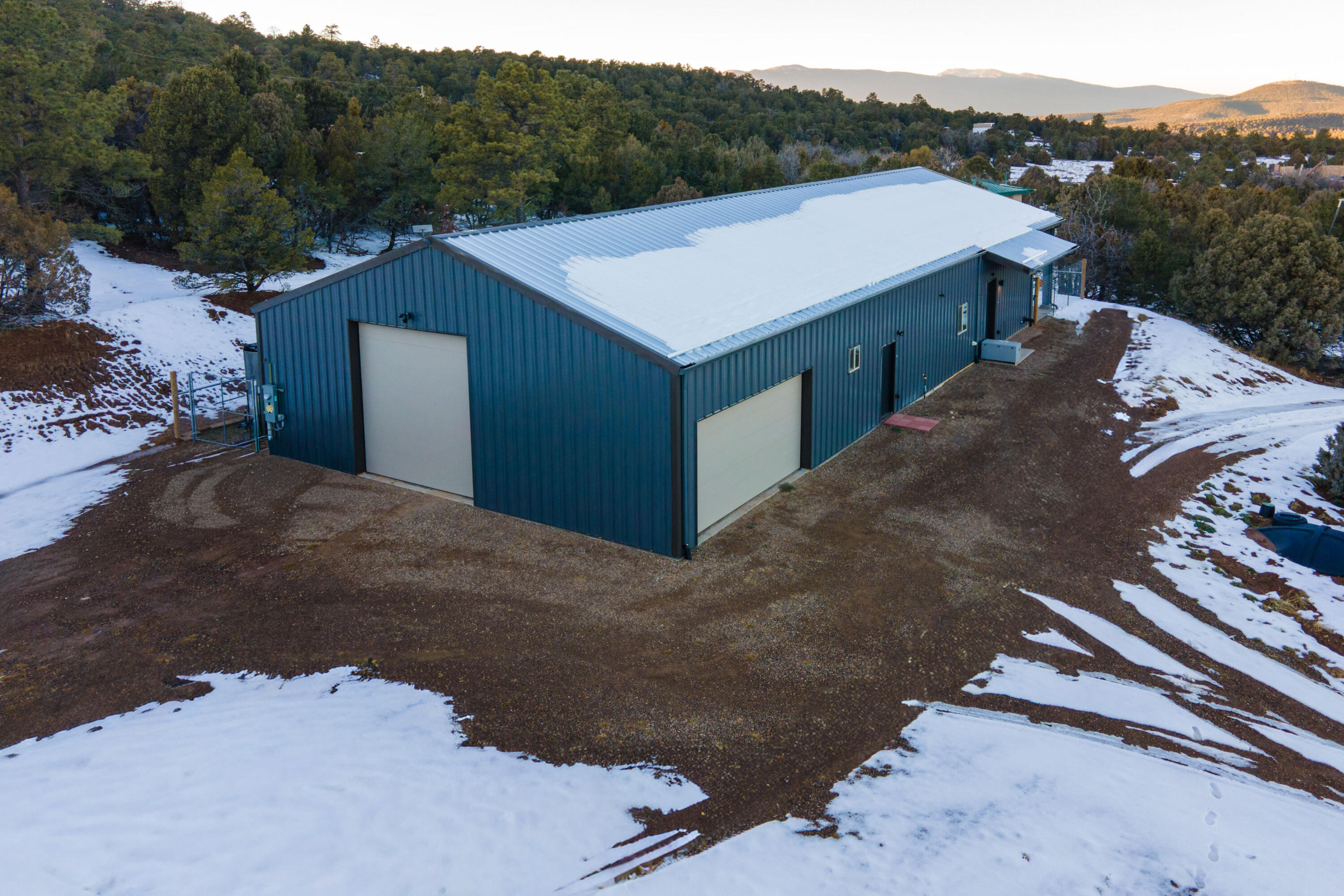 OPEN SAT 12-2 PM. Escape to the mountains & enjoy this gorgeous, fully custom ''shopdominium'' just completed in May of 2025. Boasting 2 beds, 2 full baths, 1437 sq ft, with fully foam insulated 30 x 47.5 attached shop, all on roughly 1 acre. RV plug-in & door, additional 2-car door, plus room for all your toys, hobbies & workshop space, this property is everything you've always wanted-shop and home all in one. Enjoy beautiful mountain views out the custom iron doors, while catching the bursting stars off the back covered patio. Outfitted with a 2500 gal cistern system, on-demand water heater & 3 mini-splits heat/cool, plus custom pellet stove, this home is built for efficiency & ease. Quick 25 mins to ABQ yet tucked away in the privacy of the trees. This property is unique & gorgeous.