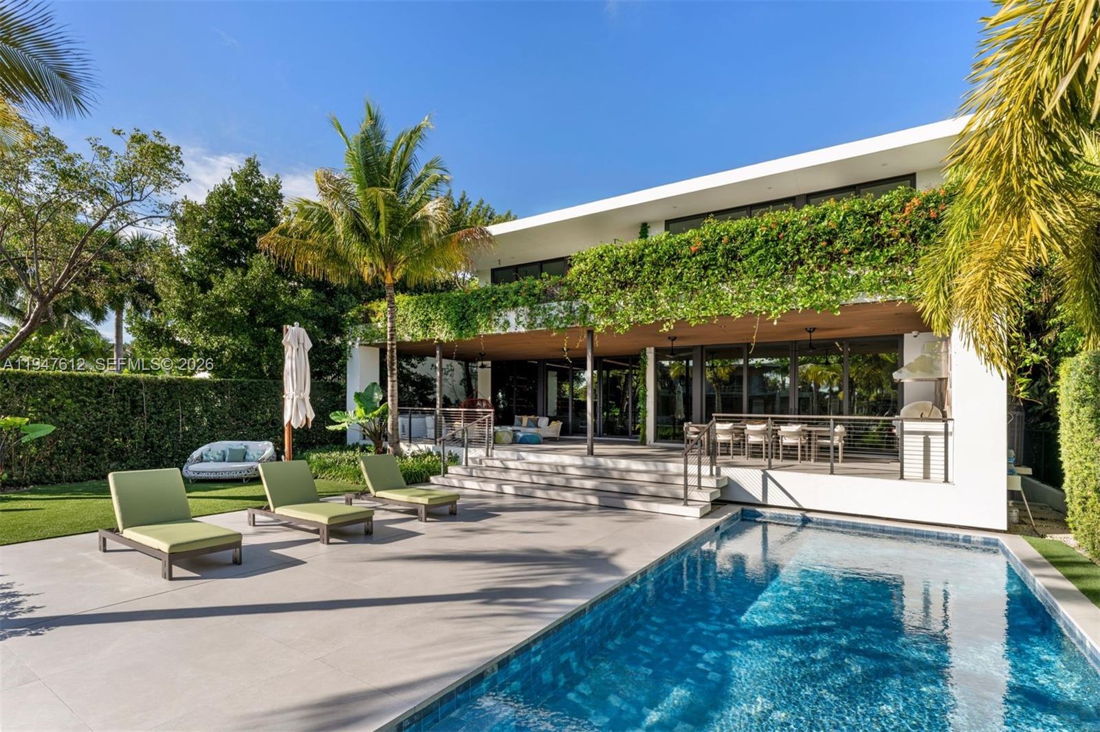 Welcome to 7333 Belle Meade Blvd, an exquisite tropical-modern sanctuary masterfully curated by 2id Interiors. Set on an 11,528 SF waterfront lot with 71’ of frontage, this residence embraces warm modern materials and sculptural lines to offer the ultimate Miami lifestyle.Bathed in natural light, the interior features 10’ ceilings and floor-to-ceiling windows framing serene water views. Elegant custom wood paneling, large Italian porcelain flooring, and a spectacular floating staircase set a refined tone. The Mia Cucina chef’s kitchen is a statement in functionality, equipped with Wolf/Sub-Zero appliances, a wine cooler, expansive island, and a fully outfitted butler’s pantry. The open layout flows seamlessly to an oversized covered terrace and BBQ pavilion for elevated entertaining.The home offers 5 spacious bedrooms plus a lofted studio office, with three bedrooms enjoying private waterfront balconies. The primary suite is a true retreat featuring a spa-style bath with a soaking tub, steam shower, and sauna. A top-tier media room with beverage center and a home gym complete the luxury experience.Outside, the property transforms into a private resort with a sparkling pool, lush landscaping, and a 60’ dock offering effortless bay access. Features include a 2-car garage, laundry w/ steam dryer, smart home integration, and 24-hour guard-gated security. A masterwork of elegance and innovation, this is the epitome of Miami modern living.