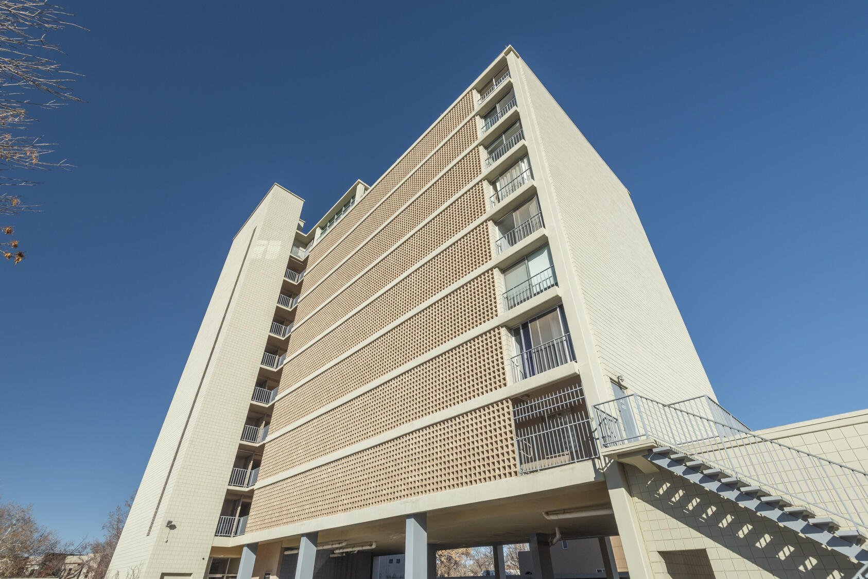 A ''casa in the sky'' at Alcalde, ABQ's landmark contemporary high-rise next to the Country Club! Vertical mid-century modern living at its finest; 1 of just 29 units in the building. Seamlessly blending vintage charm w/modern aesthetic & a color palette in the soothing blue-gray spectrum. Living room opens to deep balcony w/original tile floor + City & Mtn views. Kitchen w/''Juliet'' balcony + black granite counters & original cabinets. Concrete floors throughout keep the vibe sleek & cool. High end custom blinds. Spacious bedroom with great storage. Full bath strikes a ''Scandinavian'' note w/wood door & vanity. Study/office could be 2nd bedroom. Refrig AC, stacked W/D, elevator service, community pool & covered parking. Enjoy life ''above it all'' in an outstanding Downtown location!