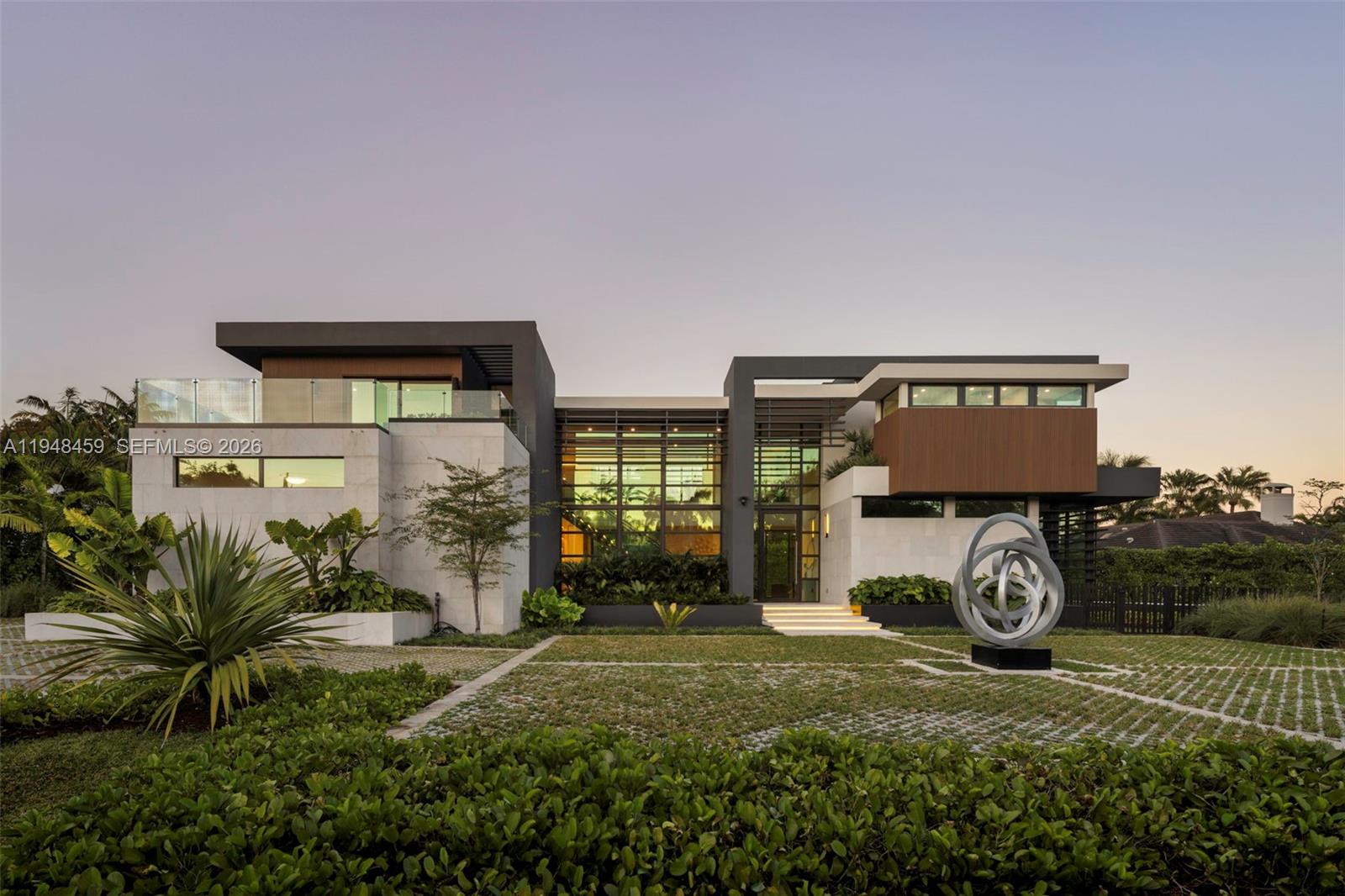 Tucked away on a quiet Pinecrest cul-de-sac, this newly completed two-story estate delivers refined modern luxury with exceptional privacy and architectural presence. Offering 7 bedrooms and 7.5 baths, the residence is thoughtfully designed with curated European finishes throughout, including warm wood tones, natural stone, and bespoke marble imported from Italy and Spain. Expansive walls of architectural glass flood the interiors with natural light while creating a seamless connection between indoor and outdoor living spaces.The chef’s kitchen is both striking and functional, featuring premium appliances, custom millwork, generous prep space, and a temperature-controlled wine display, all opening effortlessly to the main living and dining areas—ideal for entertaining at scale or intimate gatherings. Elevator access serves both levels for added convenience.The primary suite is a true private retreat, complete with a sitting lounge, serene views, and a spa-inspired bath featuring a skylight, soaking tub, dual vanities, and refined stone finishes. Additional bedrooms are well-appointed and thoughtfully positioned for comfort and privacy.Resort-style grounds complete the offering, showcasing an infinity-edge pool, guest house, and lush, tranquil landscaping that enhances the sense of seclusion. A rare opportunity to own a newly built, design-forward residence in one of Pinecrest’s most desirable settings.