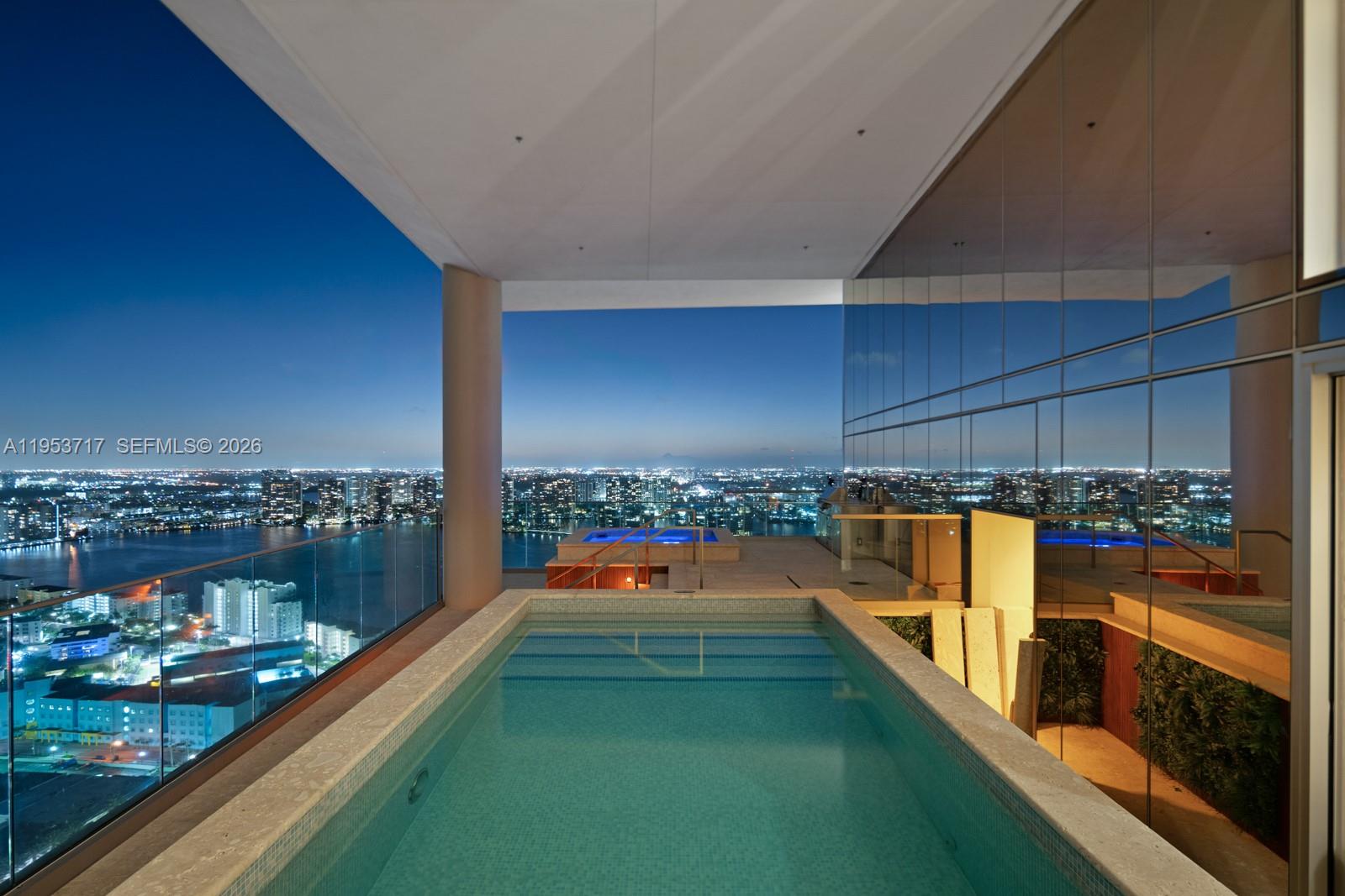 Exceptional sky villa at Turnberry Ocean Club offering approx. 11,300 SF total with 7,000 SF of refined interiors and 11’ ceilings, complemented by dramatic 22’ double-height foyer and living spaces. Coveted flow-through design captures breathtaking Atlantic Ocean and Intracoastal views. An expansive 4,000 SF covered loggia finished in coral stone and teak features a private pool, spa, built-in BBQ, and enhanced glass railings for seamless indoor-outdoor living. The oceanview primary suite is highlighted by a boutique-style dressing room with a walk-in safe overlooking the ocean. Along with luxurious ivory onyx his-and-her baths with Dornbracht fixtures and Toto Zero-Gravity Tub. Custom Snaidero cabinetry, Gaggenau appliances, designer bedroom suites with expanded closets, Control4 smart home, private beach cabana, and 4 parking spaces.