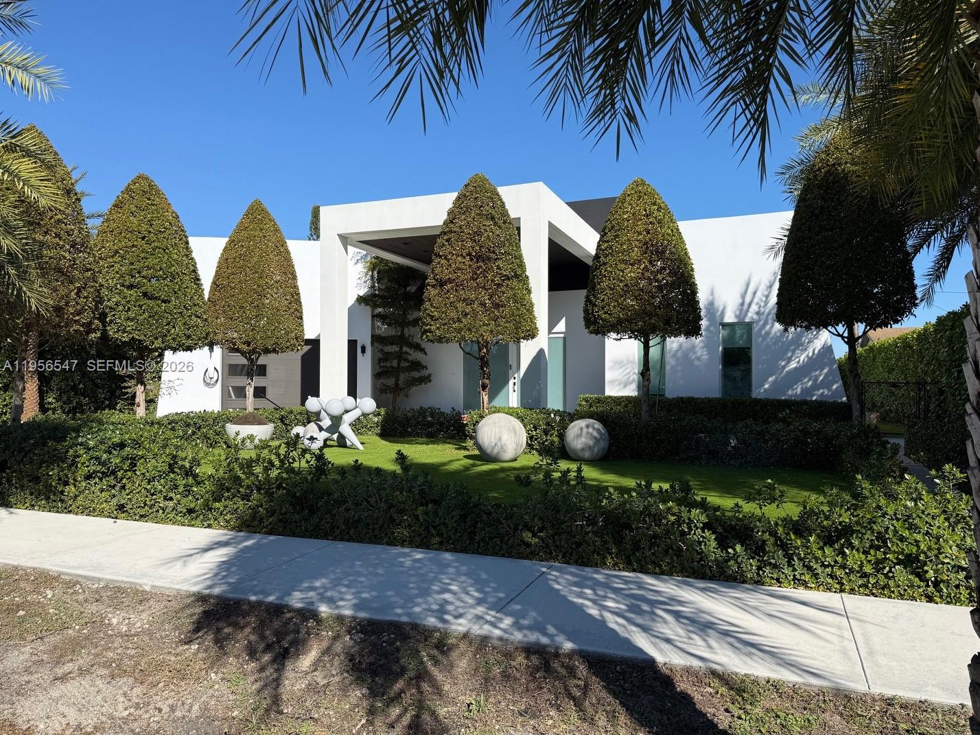 Welcome to this stunning custom-built modern jewel, where sleek design meets effortless luxury. This exceptional residence offers 4 spacious bedrooms and 3 beautifully appointed bathrooms, crafted with meticulous attention to detail throughout.At the heart of the home is a state-of-the-art gourmet kitchen, featuring premium high-end appliances and an elegant design perfect for entertaining and memorable family gatherings. The open-concept floor plan is enhanced by soaring 12-foot ceilings and an abundance of natural light that flows seamlessly throughout the space.A striking full wraparound wall of glass creates a seamless indoor-outdoor experience, offering breathtaking views of the pool and elevating everyday living. The thoughtfully designed layout includes a private fourth bedroom with its own bathroom, ideal for guests, in-law quarters, or a home office retreat.Additional highlights include hurricane-impact windows and doors, exquisite craftsmanship, and a one-car garage for added convenience. This is modern luxury living at its finest—stylish, functional, and truly move-in ready.