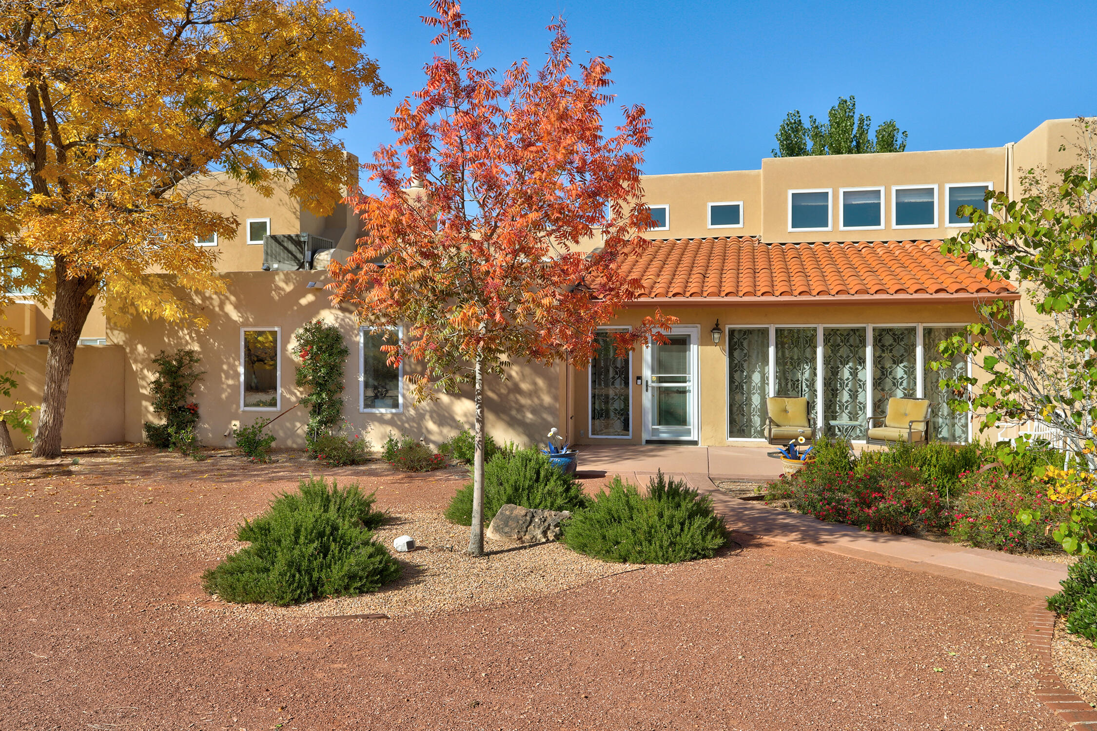 Nestled on a quiet cul-de-sac in the desirable Matthew Meadow neighborhood, this exceptional .67-acre estate offers approximately 4,724 sq ft of distinctive elegance, thoughtful design, and resort-style living. With 5 bedrooms, including two private primary suites, plus multiple living and entertaining spaces, this home blends comfort, character, and unforgettable views. From the moment you enter, architectural details set the tone -- tongue-and-groove ceilings with exposed beams, pressed tin accents, solid wood doors, wood windows, and abundant natural light throughout. The main living room features a hand-carved adobe fireplace, clerestory windows, and a wet bar, all overlooking the patio and heated in-ground pool. The beautifully remodeled kitchen