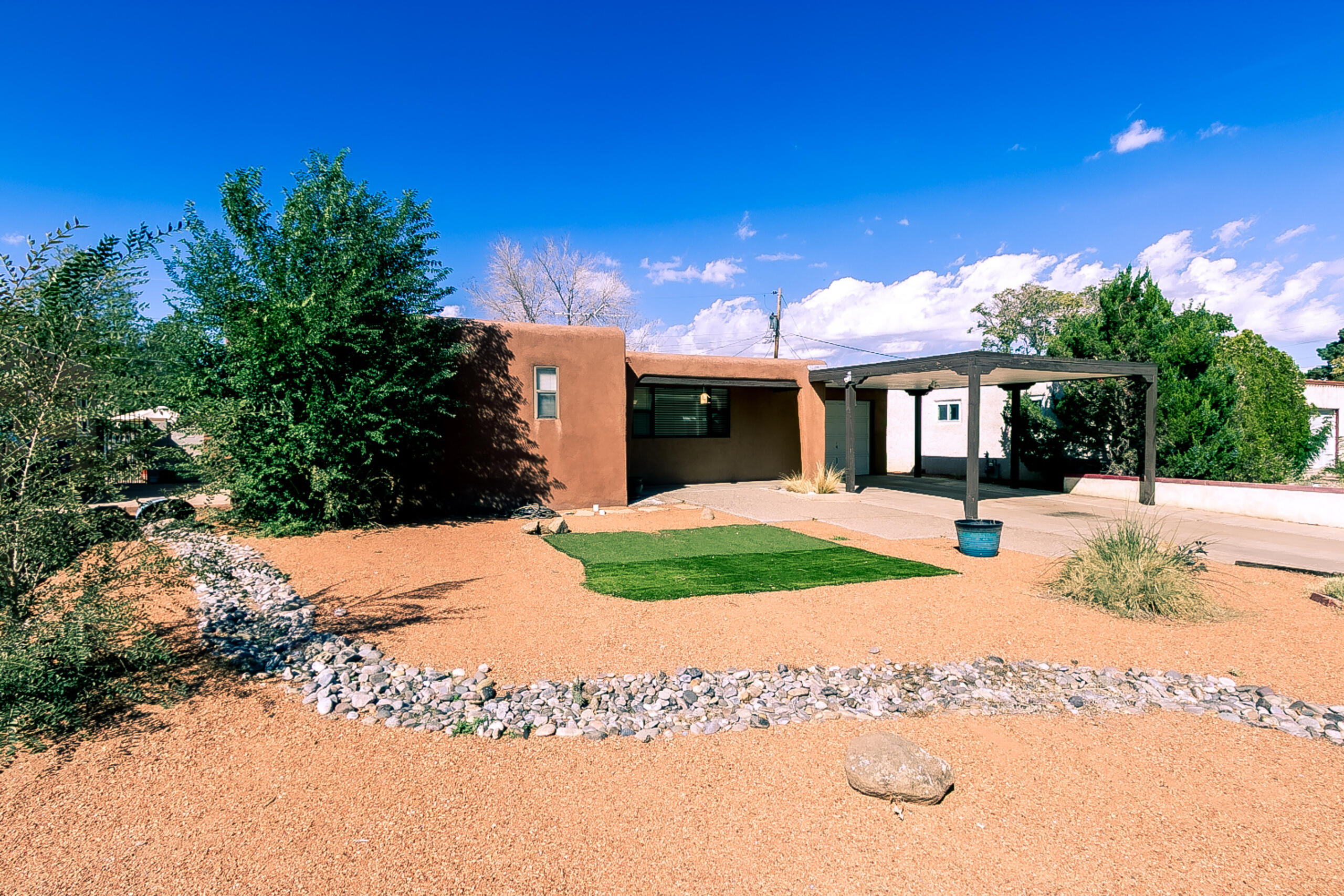 Single-story Pueblo-style home near Uptown ABQ w/4BR, 3BA & 2 owner suites! Features recently refinished original oak hardwood , large picture window in living area, & updated baths incl. cultured marble surrounds. Kitchen offers upgraded cabinetry, SS 5-burner gas range, vent hood, DW, built-in desk, breakfast nook & window overlooking backyard. Large laundry rm w/folding table & gas hook-ups. Hot-water baseboard heat, 2 evap units (1 MasterCool + 1 traditional), new boiler, pumps & venting. Backyard w/covered patio, bancos, stuccoed block walls. 1-car garage + expanded carport.