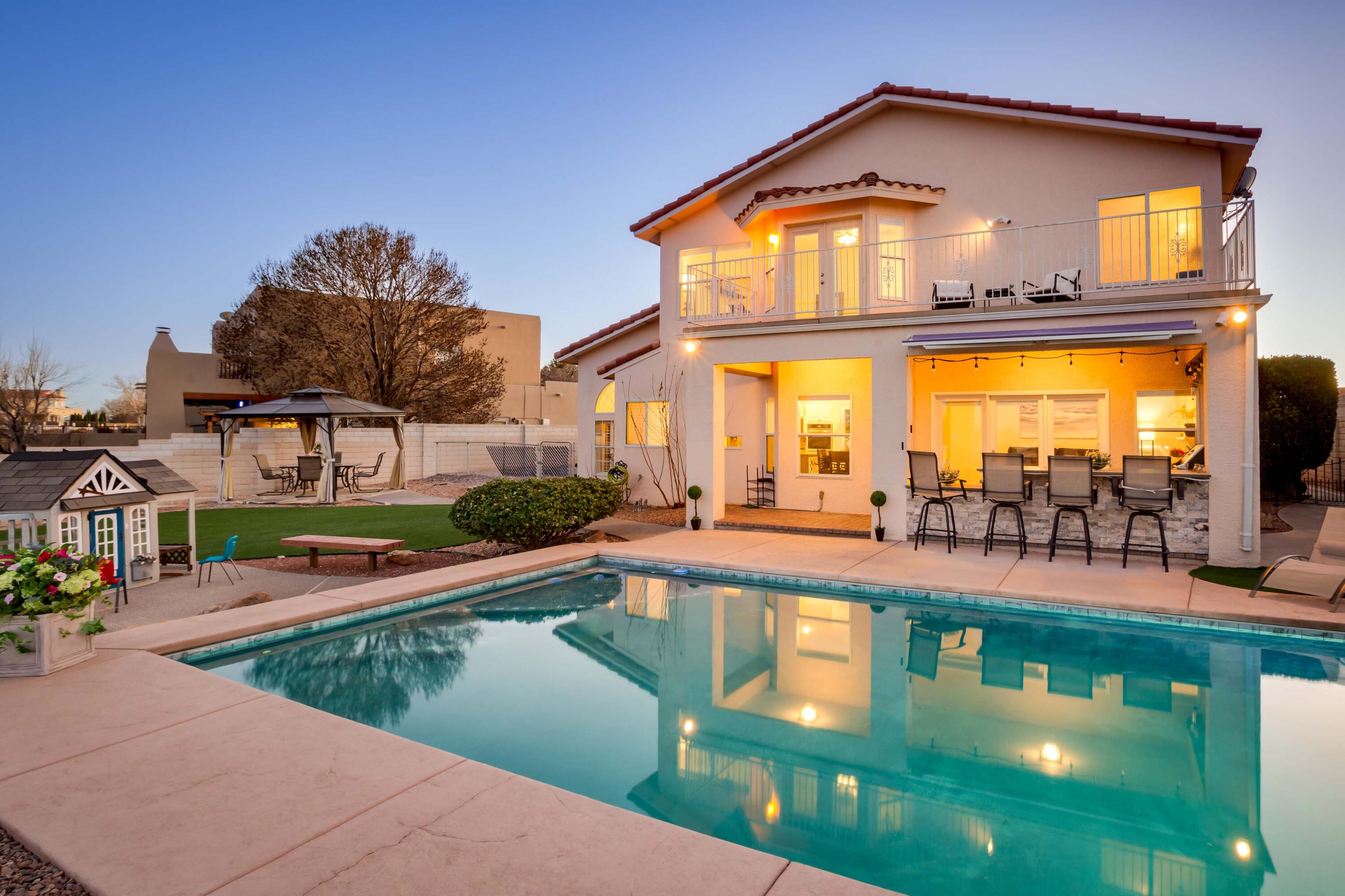 Stunning light-filled custom home with both Sandia mountain and city light views. Incredible outdoor entertaining space with glimmering heated POOL, outdoor kitchen, and gorgeous yard. Vaulted ceilings greet you as you enter the open living/dining room. Modern updated kitchen with two-tone cabinets, granite counters, SS appliances that overlooks the backyard. Beautiful family room with gas-log fireplace. Bedroom or office space with a 3/4 bathroom on the lower level. Upstairs includes 3 spacious bedrooms. Luxury defines the primary bedroom with views from the private balcony, large walk-in closet, double vanity plus a garden tub. Home has so many amenities including new carpet, a new HVAC system, SOLAR (that has been paid in full), handsomely finished 3-car garage, & a brand new ROOF.