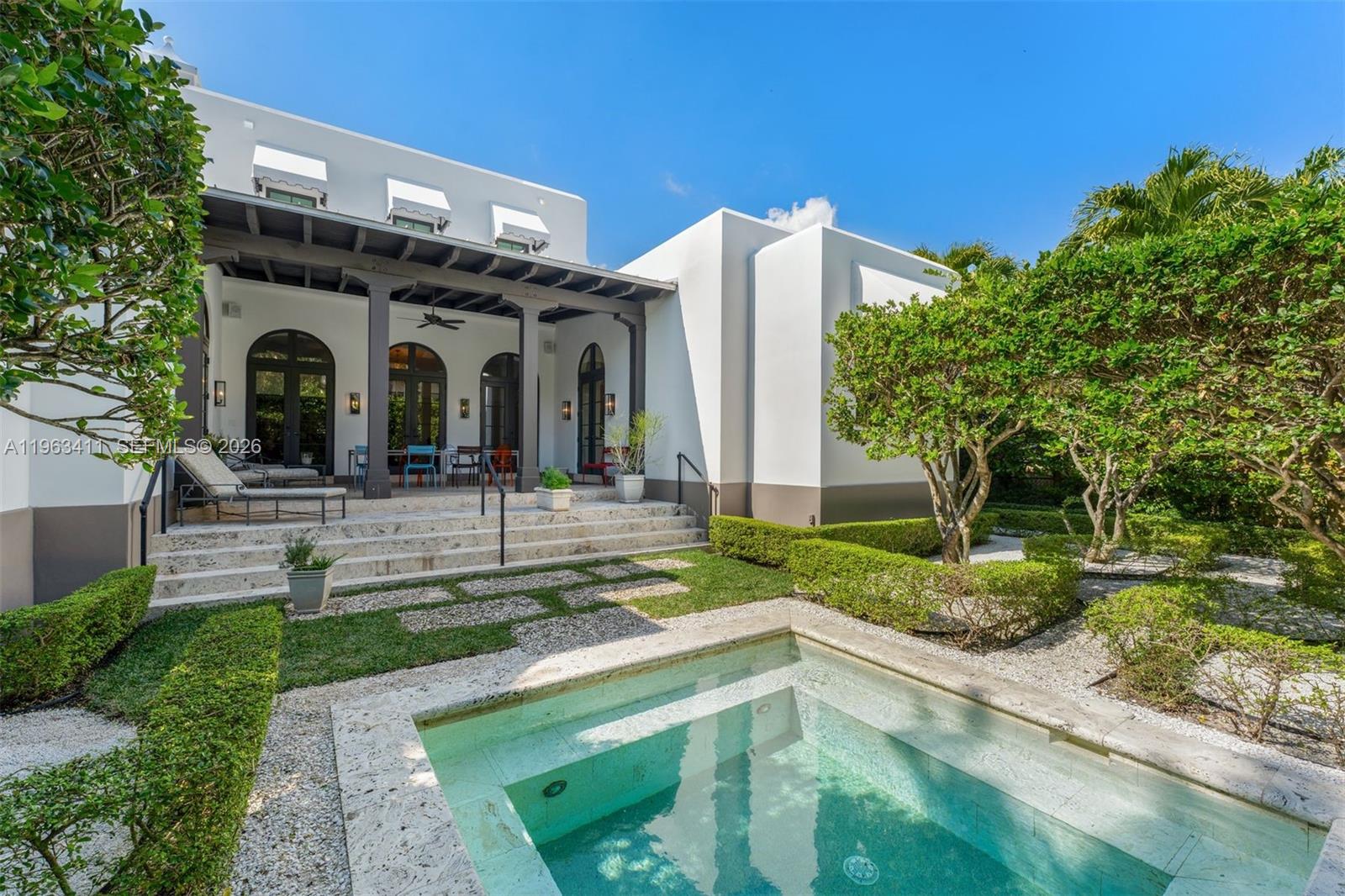 Timeless Mediterranean elegance meets refined modern living in this exquisitely designed residence. Framed by graceful arches, soaring ceilings, and black steel-framed windows and doors, the home is bathed in natural light and rich architectural character throughout. Renovated by current owners in 2022. Roof is 4 years new.Grand living and entertaining spaces feature stone flooring, custom millwork, and curated designer lighting, creating a warm yet sophisticated ambiance. The chef’s kitchen is both functional and beautiful, offering expansive cabinetry, premium appliances including gas range, and a statement island that anchors the space while maintaining seamless sightlines through dramatic archways. Beach Club Membership.The primary suite is a private sanctuary, complete with layered architectural detailing, serene garden views, and a spa-inspired bath featuring marble finishes, dual vanities, and a freestanding soaking tub.Indoor-outdoor living is effortless. A covered loggia with exposed beam ceilings provides the perfect setting for lounging or dining al fresco, overlooking lush tropical landscaping. The intimate garden retreat is highlighted by a tranquil plunge pool, manicured hedges, and multiple seating areas—ideal for both relaxation and entertaining.Blending classic Mediterranean design with modern comfort, this residence offers privacy, sophistication, and resort-style living in an exceptional setting.