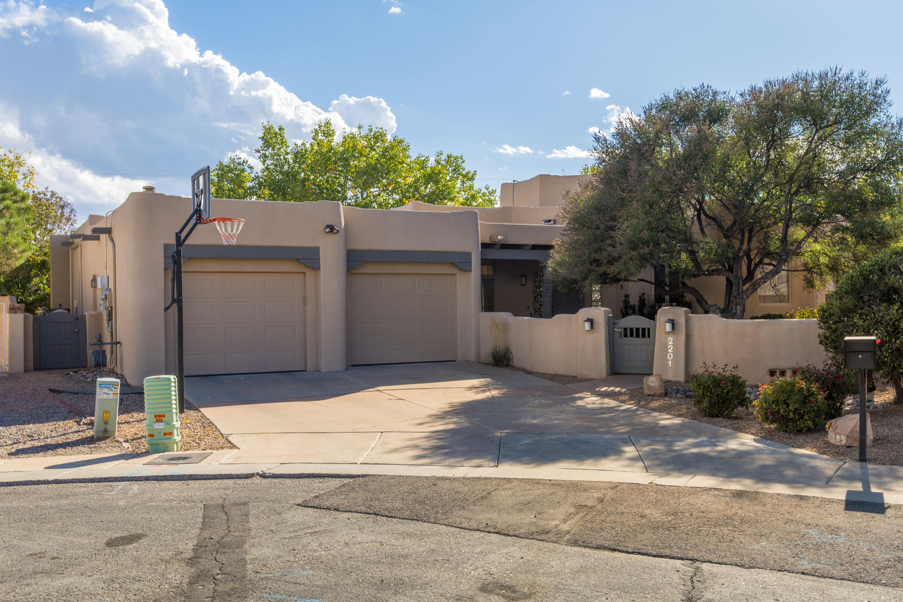 Beautiful custom home in The Meadows on Rio Grande in the heart of Albuquerque's North Valley. Enjoy a lush, serene setting with mature trees, green grass, and access to scenic acequia paths that connect to the Bosque Trail along the Rio Grande. This single-story residence offers a bright, open floor plan with no interior steps and walls of windows overlooking the stunning backyard. Classic Southwestern details shine throughout, including beamed ceilings, a kiva fireplace, stained concrete floors, and graceful curved walls of windows.The private backyard is perfect for relaxing or entertaining, featuring a covered patio and sparkling pool for warm New Mexico evenings. The spacious primary suite is a retreat with a beautifully updated bath, walk-in closet, and separate sitting area.