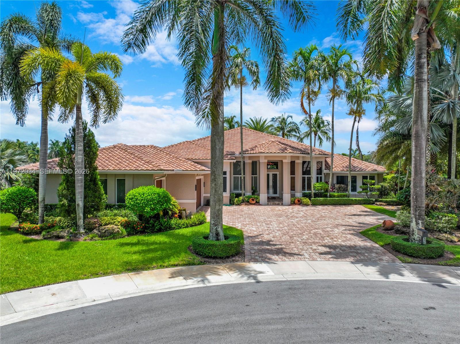 Experience luxury, comfort, and privacy in this beautifully renovated one-story estate offering over 5,200 sq ft of living area in the prestigious Weston Hills community. Nestled on a cul-de-sac with serene lake views, this home features 6 bedrooms, 6.5 bathrooms, a dedicated office, and a private gym space—ideal for modern family living and entertaining.Enjoy peace of mind with impact windows and doors and a roof approximately 10 years old. The expansive interior showcases oversized living areas and a thoughtful split layout. The primary suite overlooks the pool and lake, and includes two large walk-in closets with built-in cabinetry, plus an additional flexible room—perfect for a gym, nursery, sitting room, or studio.In a separate wing, you’ll find four en-suite bedrooms, each with walk-in closets and private baths, providing exceptional comfort and privacy. A spacious additional room next to the cabana bath can serve as a second office, playroom, media room, or guest suite.Step outside to your private resort-style backyard featuring an amazing patio, pool, and BBQ/entertaining area, all set against the tranquil lake backdrop. This is Florida living at its finest in one of Weston’s most sought-after communities.