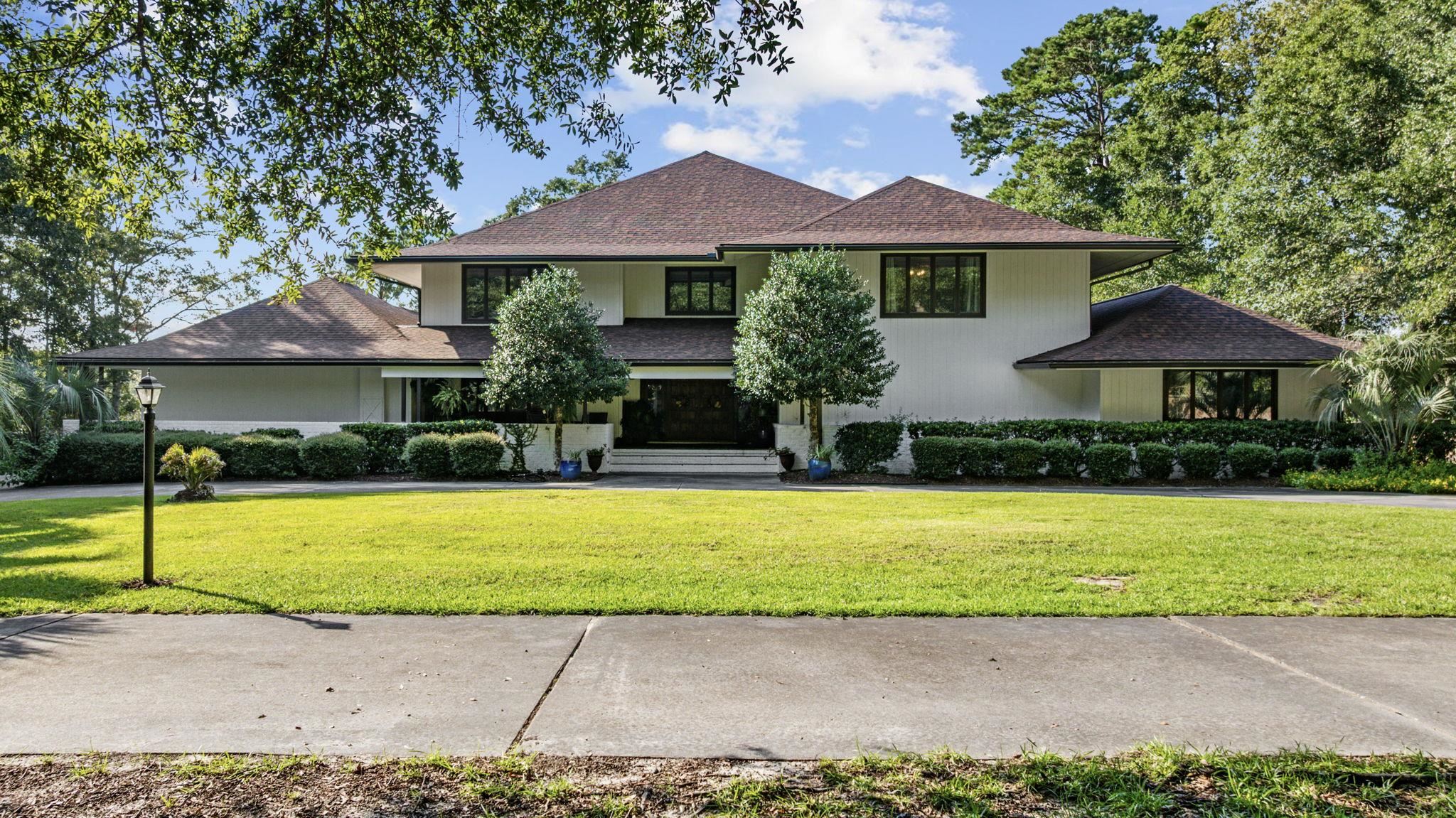 Welcome to Black River Retreat, where timeless design meets modern luxury. Inspired by Frank Lloyd Wright’s architectural vision, this extraordinary 8,200 sq. ft. residence sits high on a bluff overlooking the tranquil Black River, with direct access to the Intracoastal Waterway and the Atlantic Ocean. Perfectly positioned on a private two-acre estate, the home has been renovated from top to bottom, with a new roof, whole-house interior and exterior paint, new gutters, and all new flooring throughout- LVP and hardwood in the main areas and carpet in bedrooms. A charming circular driveway welcomes you through the iron gates, leading to the steps of a custom front door and into the grand foyer. Moving into the home, the soaring living room features large windows capturing breathtaking water views, along with newly added columns and a cozy propane fireplace. The state-of-the-art kitchen is a chef’s dream, fully reimagined with new tile floors, an oversized gas range with 11 burners, a double oven, new cabinets, a spacious island with granite countertops, custom tile backsplash, under-cabinet lighting, and top of the line stainless steel appliances. This kitchen truly shines with new lighting and fans, and a kitchen and dining room of this caliber can effortlessly accommodate holiday feasts, dinner parties, or casual weekends by the river. The primary suite has been transformed with new LVP flooring, a new custom walk-in closet, new barn doors, and abundant natural light. Its luxurious ensuite boasts dual vanities, a spa-like freestanding tub, and a custom tile shower. Two additional first-floor bedrooms share a Jack-and-Jill bath, while four more bedrooms upstairs provide space for family and guests. A dramatic centerpiece of the home, the custom staircase makes a striking architectural statement. With dual entries, elegant wood railings, and soft carpet inlays, it gracefully connects the main level to the private quarters above. The open design allows light to flow seamlessly throughout the foyer and dining areas, creating a sense of grandeur while still feeling warm and inviting. The third-floor 22x24 retreat offers endless potential as a recreation room, studio, or extra storage. The home’s extensive updates include first and second floor porches that were rebuilt with a new foundation and resurfaces with Trex decking, new concrete-wrapped structural columns, and sleek cable railings with aluminum top rails. Additional upgrades include a new whole-house water filtration system, tankless hot water heater, and 250-gallon propane tank. Three bathrooms have been completely remodeled, while the other 1.5 bathrooms have received upgrades. The home’s exterior showcases timeless cedar siding for natural beauty and durability. Outdoor living here is truly unmatched! The saltwater pool has been completely resurfaced, upgraded, and surrounded by inviting spaces for relaxation. A brand-new walkway leads to the river, where a new floating dock, additional fishing dock, and private gazebo provide endless opportunities to enjoy the water. To elevate the waterfront lifestyle even further, the sale includes a 2020 20-foot Bennington pontoon boat powered by a Yamaha motor, perfect for cruising the river. A new 12x16 shed with large custom smoker adds function, while the expansive grounds offer both privacy and recreation while combining craftsmanship and riverfront serenity. From its modern upgrades and breathtaking setting, this residence represents the ultimate blend of luxury, comfort, and waterfront living.  Click on the unbranded video tour link above to view all 137 photos. See the 2nd Unbranded Virtual Tour for a stunning video tour of this property!