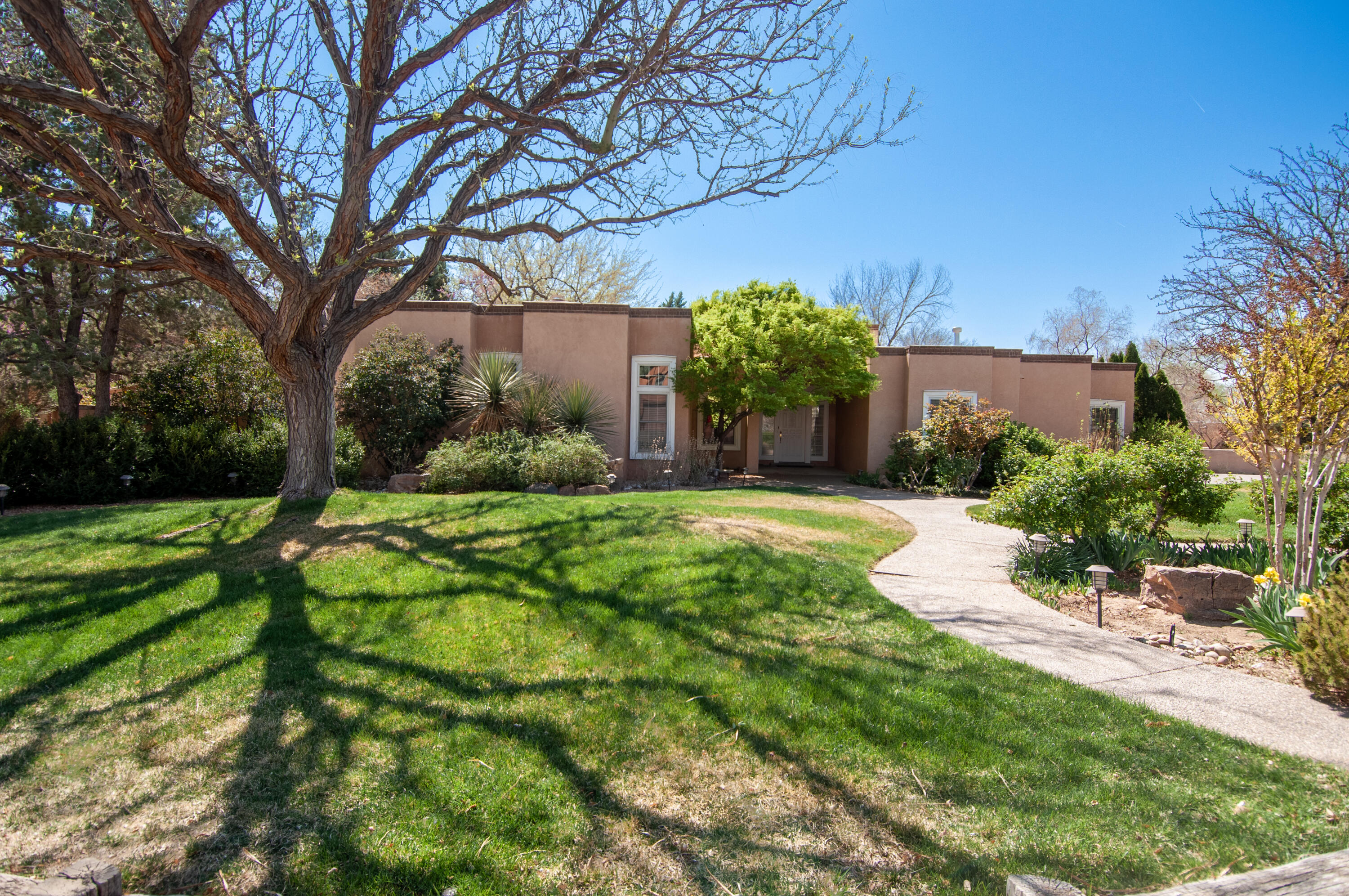 Whether you're seeking tranquility or easy proximity, this jewel offers both! Las Colinas Territorial sits on a landscaped .36-acre lot with mature trees and peaceful fountain.  From entry step down into living room with soaring ceilings, cozy fireplace, and wet bar. Leading into primary is an area for relaxing, small office or seating.  Spacious primary suite has sitting area, double-sided gas fireplace, outside door, and a luxurious ensuite with dual sinks, 2 walk-in closets, soaking tub, separate shower. 2 more large BRs share an updated JnJ bath. Updated half bath for guests.  The sun-drenched kitchen features granite counters, breakfast bar, and slider leading to a tranquil patio. 2024 roof. Pella windows. Refrig Air.  Oversized 2-car garage with ample storage. Backyard access.