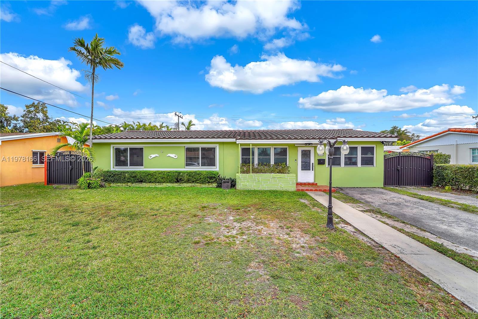 Stunningly expanded 5-bedroom, 3-bathroom residence in the desirable Coral Park Estates. This solid CBS-constructed home offers 2,292 sq. ft. of living space, featuring a thoughtful split-plan layout designed for large families. The interior is finished with neutral tile throughout and includes a spacious living room, formal dining, and a sun-drenched family room. The former garage has been seamlessly integrated into the floor plan as a versatile 18-foot flex space, perfect for a home office, gym, or playroom. Retreat to the primary suite featuring a massive walk-in closet and private bath. The highlight of the home is the expansive 30x14 covered rear terrace with a built-in bar, overlooking a fully fenced 7,500 sq. ft