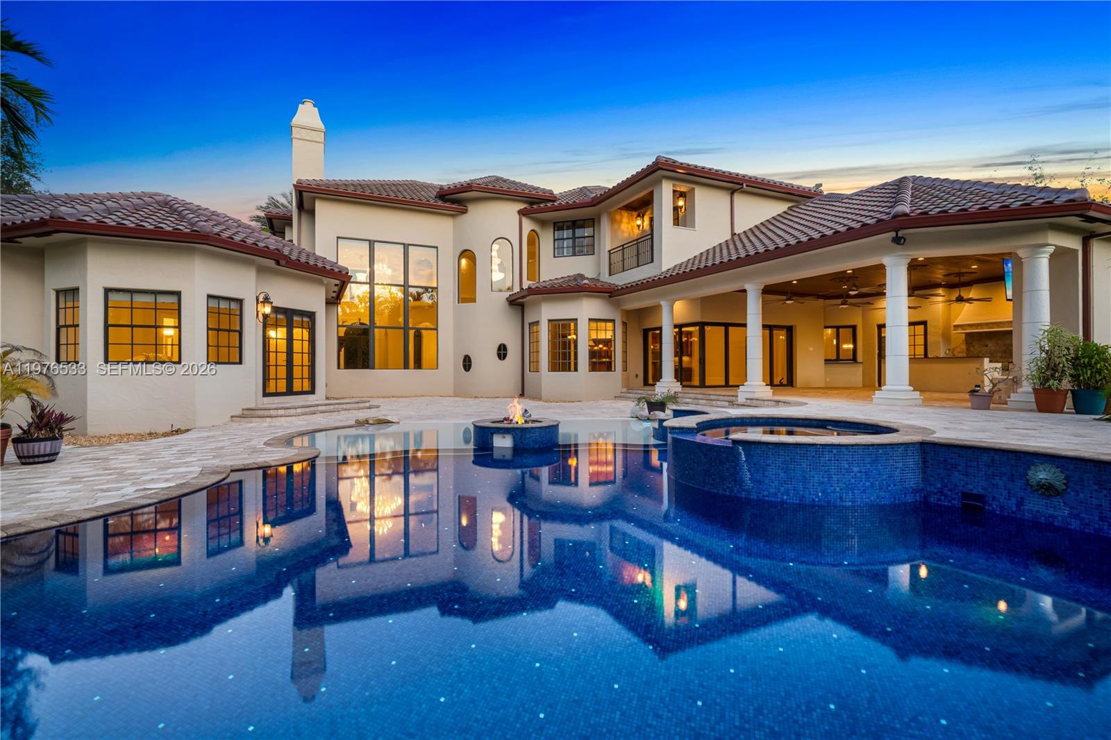 Perfectly located in the heart of Pinecrest along one of its most desirable corridors, this gated estate is tucked away on a lush acre-plus lot, offering privacy and convenience just minutes from top schools, parks, and the best of Miami living. Designed for comfort, entertaining, and effortless luxury, the residence features 7 bedrooms plus a private office, including a sumptuous primary suite on the ground floor overlooking the pool with soaring ceilings, designer lighting, and two oversized walk-in closets. The marble primary bath offers a soaking tub, an oversized shower ready for a steam system, and refined finishes.  At the center of the home, the chef’s kitchen is equipped with Thermador refrigeration, gas range, double ovens, hidden pantry, and breakfast nook. The kitchen flows into a spacious great room with fully retractable doors, seamlessly blending indoor and outdoor living. Entertainment spaces include a game room with full bar and cabana bath, temperature-controlled wine cellar, and multiple laundry areas.The home is fully wired for centralized audio/video control with LED lighting and Hunter Douglas blinds throughout, while a striking cylindrical elevator connects the levels. Car collectors will appreciate the three-car garage with lifts accommodating up to six vehicles. Outdoors, enjoy a heated saltwater pool finished in dark blue glass, propane fireplace, twilight landscape lighting, and expansive grounds. New roof - 01/26. Generous setbacks for privacy.