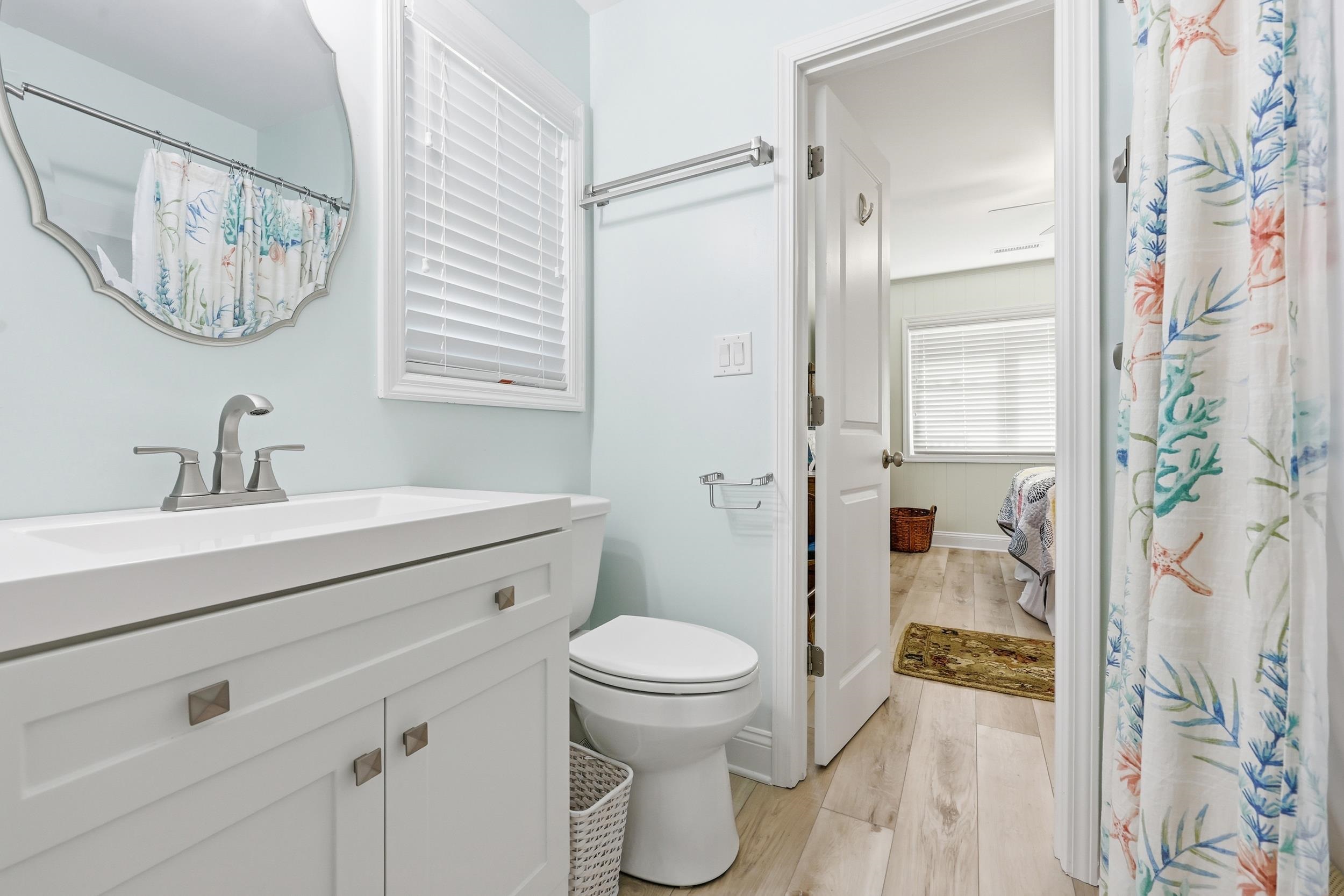 Full bathroom with vanity, light wood-style floors, and a shower with curtain