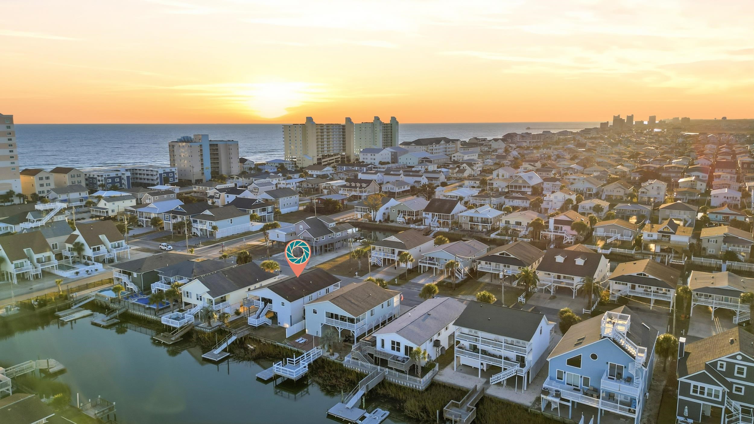 Aerial perspective of suburban area featuring a nearby body of water