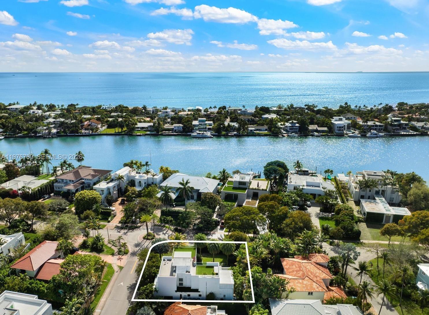 Refined 3-story modern contemporary residence on an oversized, beautifully landscaped corner lot along Key Biscayne’s prestigious Harbor Drive, just 15 minutes from the Brickell Financial District, and featuring a spectacular rooftop terrace. This 5,328 total SF home offers 6 bedrooms, 4 full baths, and 3 half baths, thoughtfully designed for both elegant living and effortless entertaining. A grand entry with a stylish pivot door welcomes you into light-filled interiors with soaring ceilings, marble floors in the social areas, and wire-brushed white oak flooring upstairs. Panoramic impact windows and multiple terraces create seamless indoor-outdoor flow. The resort-style backyard features a heated saltwater pool with waterfall and inviting lounge areas. The Mia Cucina chef’s kitchen anchors the main living space with a marble waterfall island, custom cabinetry, and premium appliances including Wolf induction cooktop/ovens, Sub-Zero refrigeration, and Asko dishwasher. Smart home technology includes Savant automation, Lutron lighting, whole-home audio, and integrated security. The expansive primary suite offers a sitting area, private balcony, covered terrace, beverage station, custom walk-in closets, and a spa-inspired marble bath. A dedicated office, upstairs family room, staff quarters, and laundry room add flexibility. The rooftop entertainment deck includes a summer kitchen with Wolf grill, Sub-Zero refrigeration, lounge areas, and a half bath—ideal for sunset gatherings.