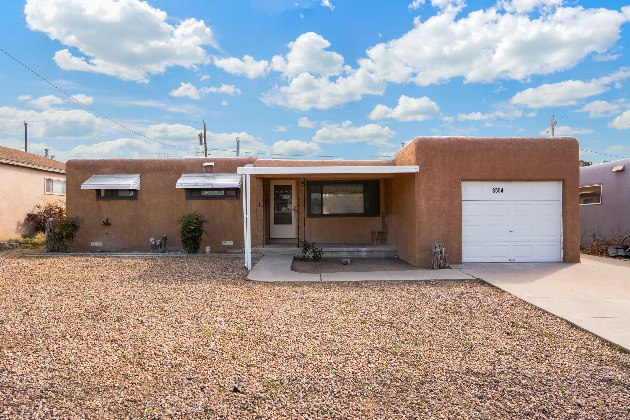 Discover a home that blends character, comfort, and location in the heart of Albuquerque's Northeast Heights. This inviting 3-bedroom, 2-bathroom property is just minutes from scenic trails, popular shops, and local dining. Step onto the welcoming front porch and into a bright, open living space highlighted by one-of-a-kind custom tile work throughout. Spacious bedrooms with generous closets provide plenty of room to unwind, while convenient backyard access adds flexibility for entertaining, hobbies, or extra parking.