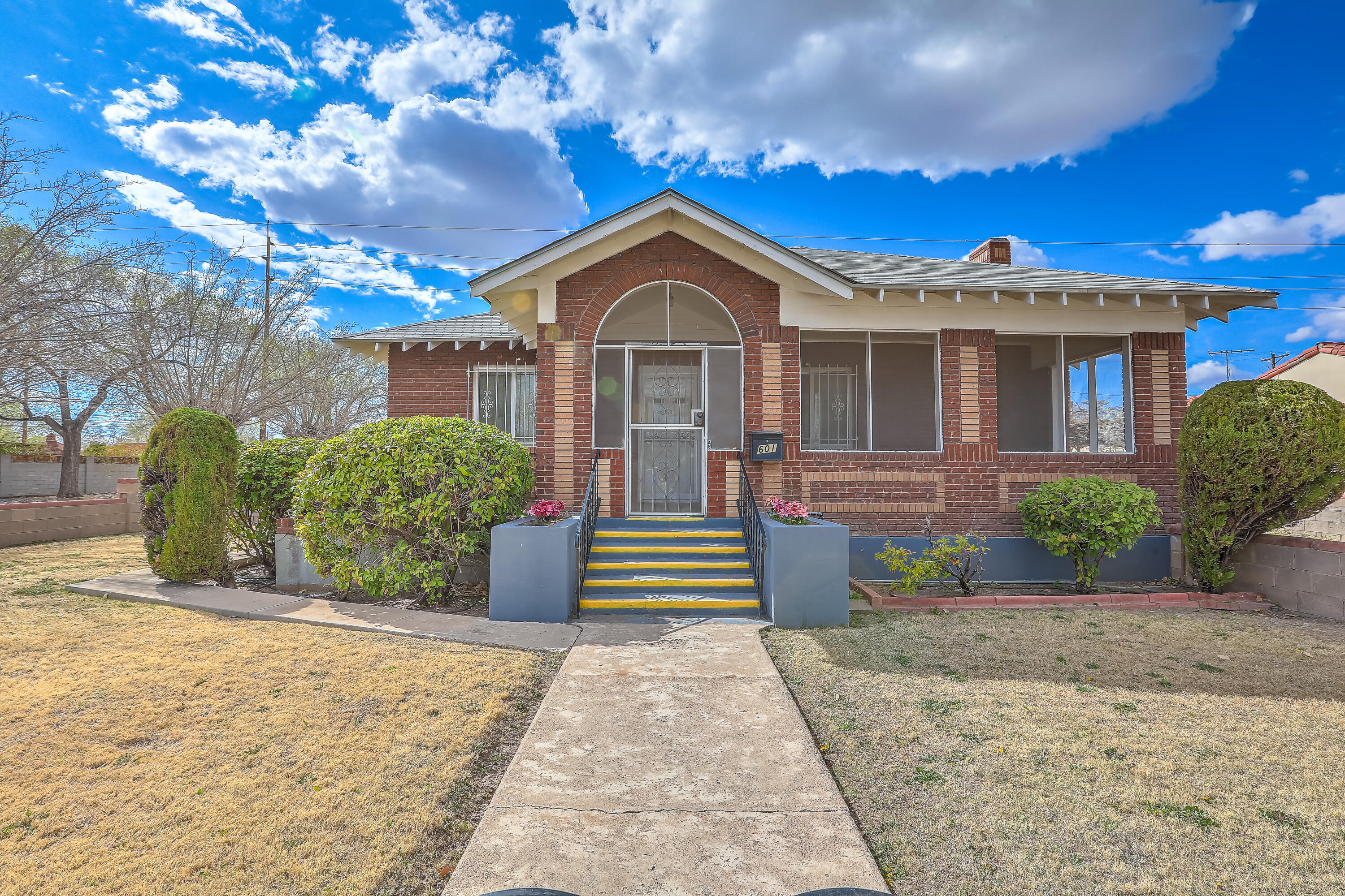Discover the charm of this classic Downtown Albuquerque gem!This home is full of character & timeless details-original hardwood floors (preserved for years beneath carpet), vintage crown molding, wide baseboards, & beautiful antique doorknobs. The main 3-BR house offers a welcoming living room w a brick fireplace, an elegant dining room, a cozy kitchen w a breakfast nook, and a 3/4 bath. Downstairs, a spacious basement (not in sf) provides laundry space, a utility sink, & plenty of storage.  Enjoy year-round living w even more flexible space: a brick sunroom & two porches.  Tucked toward the back of the .24-acre property, sits a charming 1 BR, 527 sq ft casita w a 1cg garage.A rare find w vintage beauty & endless potential. Come see the possibilities & make this diamond in the rough your