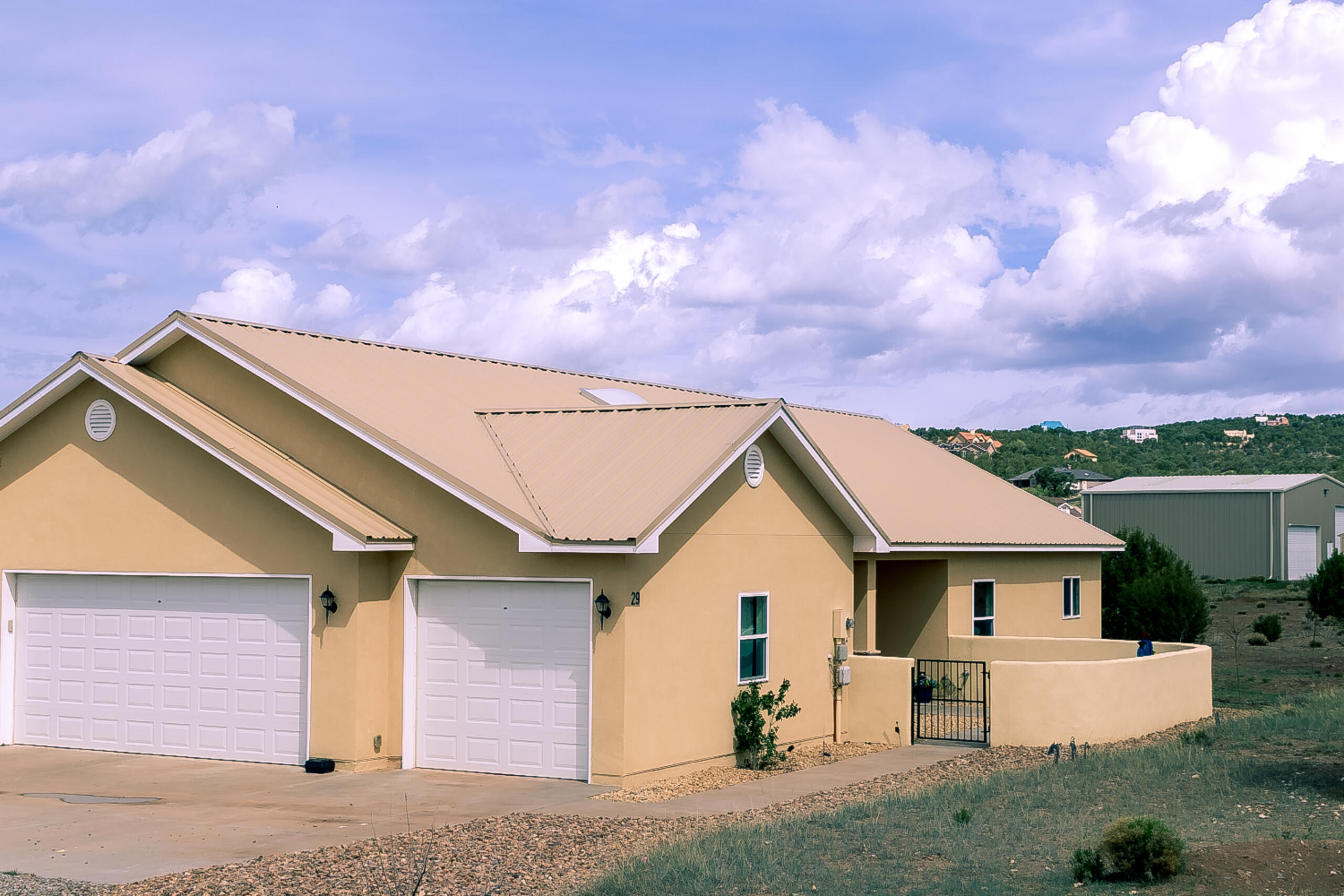 Custom home in Sandia Park NM on 2.36 acres with stunning Sandia Mountain views! Open floor plan w/ cathedral ceilings, picture windows & wood plank tile flooring throughout (carpet only in primary). Kitchen features SS Dbl ovens, 5 burner cook top, microwave, dishwasher, walk-in pantry, island w/ breakfast bar, pendant lighting, skylights & granite counter tops. Living area incls pellet stove w/ stack stone hearth. Spacious primary suite offers a large walk-in closet, bathroom w/granite countertops, dbl sinks, jetted tub &walk-in custom tile shower. Expansive covered patio w/ ceiling fans, mountain views and fenced section for pets. Addit features incl refrigerated AC, solid wood doors, community water, vinyl double-pane windows 843 sq. ft. oversized garage & water softener, RV parking.