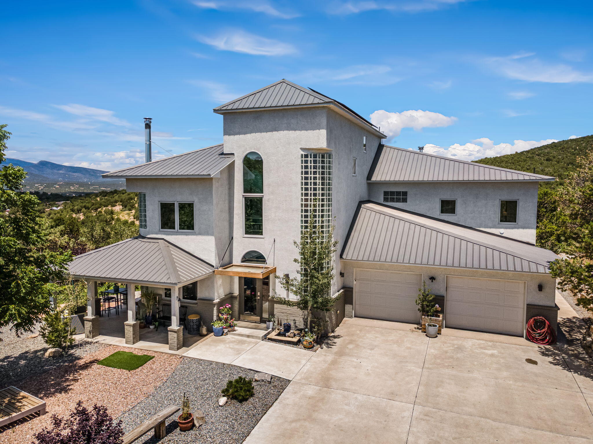 360 VIEWS AND SO MUCH NATURAL LIGHT! 4.68 Private wooded acres on two lots. No HOA! SOLAR PD OFF at closing w/acceptable offer. 890 sf of 8' high concrete floor crawl space/storage/mechanical room is one of the most unique in the east mountains. It features an oversized 33.9x24 TANDEM style garage, garage with workshop space, automatic gate, vaulted ceilings, natural light, exposed wood beams, large casement windows, multiple outdoor seating areas, covered porch w/views, hot tub, community water-no well. Water softener. Oversized ''Zen'' chair facing the Sandias for beautiful sunset views. Chicken coop & goat pen, access to trails and open space through back gate.  The home is open & inviting. The property will take your breath away!