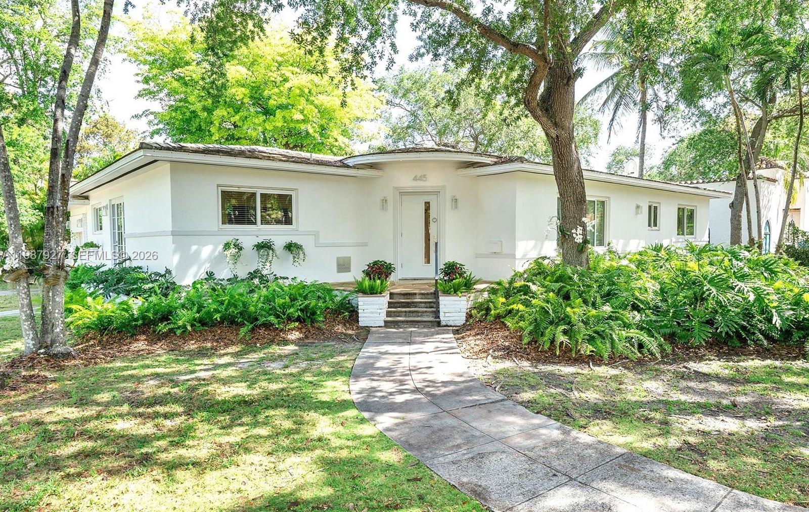 Welcome to Villa Moderne — a rare and iconic Streamline Moderne residence designed by renowned MiMo architect Manfred Ungaro and completed in 1949. Beautifully reimagined, this home blends architectural history with modern luxury. Situated on a prominent 11,300 SF corner lot, the residence offers 2,204 SF of living space, featuring 3 bedrooms, 3 bathrooms, and a powder room. Natural light fills every room through impact windows, highlighting elegant interiors, Red Oak hardwood floors, and a stunning dining room with signature seafoam terrazzo. The chef’s kitchen, recently showcased at the Coral Gables Tour of Kitchens, is both functional and refined, with Snaidero cabinetry, Miele appliances, and a generous pantry. A stylish wet bar discreetly conceals the laundry area, enhancing both design and practicality. Set on a quiet, tree-lined street, the property offers exceptional outdoor potential, including pre-approved plans for a pool and terrace—perfect for entertaining or relaxing in privacy. Ideally located just moments from Miracle Mile, fine dining, and top amenities, with convenient access to Miami International Airport. A distinctive residence where timeless design meets modern living.