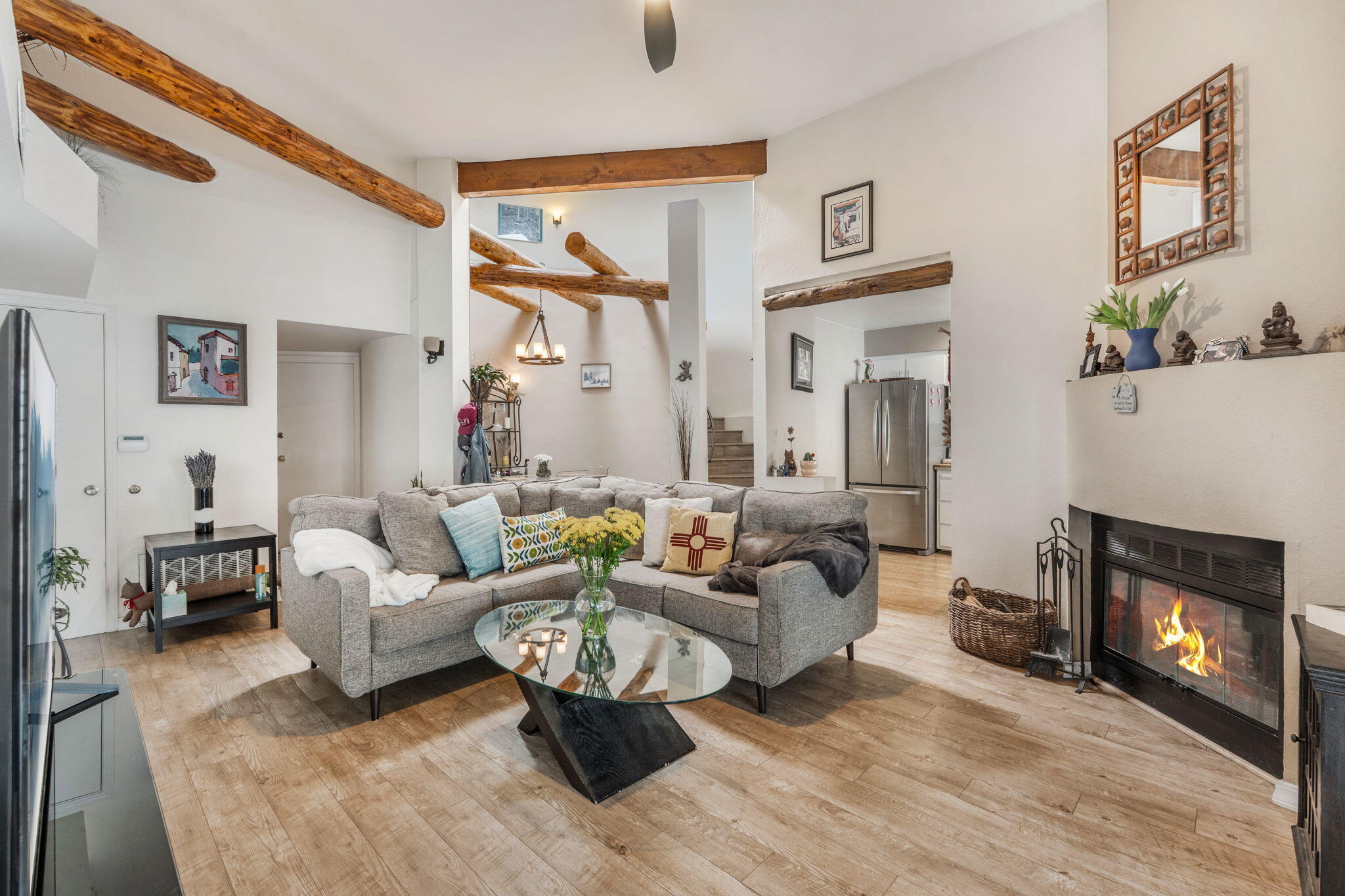 Tucked away in Albuquerque's desirable North Valley, this charming 2-bedroom, 1.5-bath townhome offers a perfect blend of NM character and modern updates. With a new TPO roof in 2025, this move-in ready home showcases soaring ceilings, exposed wood beams, a classic kiva fireplace, and architectural elements that creates a warm and inviting atmosphere. 2 car garage. Meticulously maintained, the home features numerous upgrades such as a newer furnace and refrigerated A/C, recessed lighting, updated flooring, and fully remodeled kitchen and bathrooms. Additional improvements include updated windows, custom wood blinds, and included washer, dryer, and all appliances--making this a truly turnkey opportunity.
