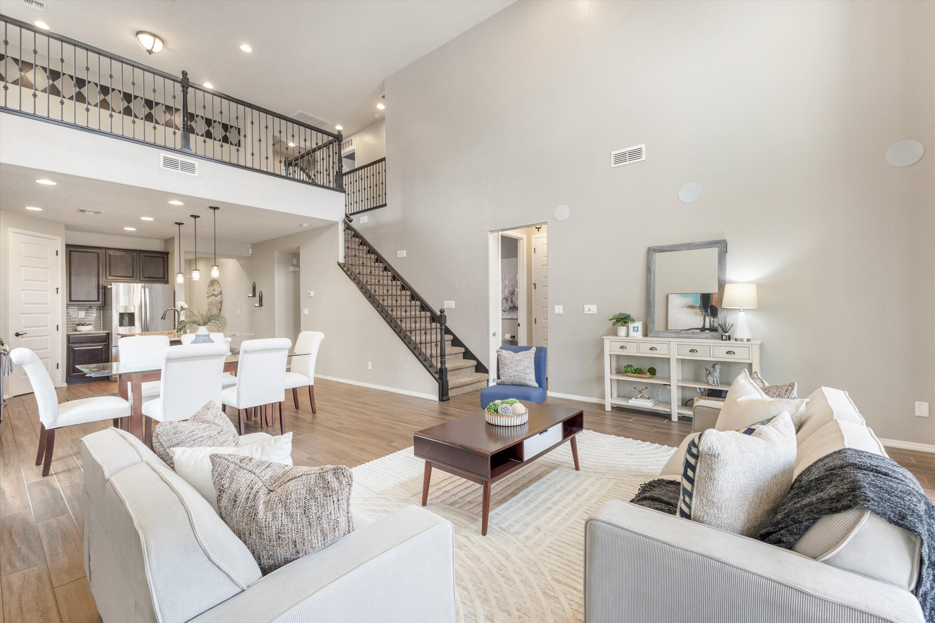 Welcome to this stunning Pulte built Firwood model home. Featuring designer accents like tile walls, custom paint, and high-end finishes throughout. The chef's kitchen boasts granite countertops and Whirlpool(r) stainless appliances, opening to a grand gathering room with vaulted ceilings. The first floor owner's suite includes a bay window for natural light and tranquility. Upstairs, a spacious loft plus three more bedrooms/game room for family or guests. Entertain outside with a built-in natural gas BBQ, basketball court, fire pit plus breathtaking Sandia Mountain views. This Build Green NM Silver Certified home includes energy-efficient features like a tankless water heater and Low-E windows. A 4-foot garage extension adds space. See this exceptional home--schedule a tour today!!