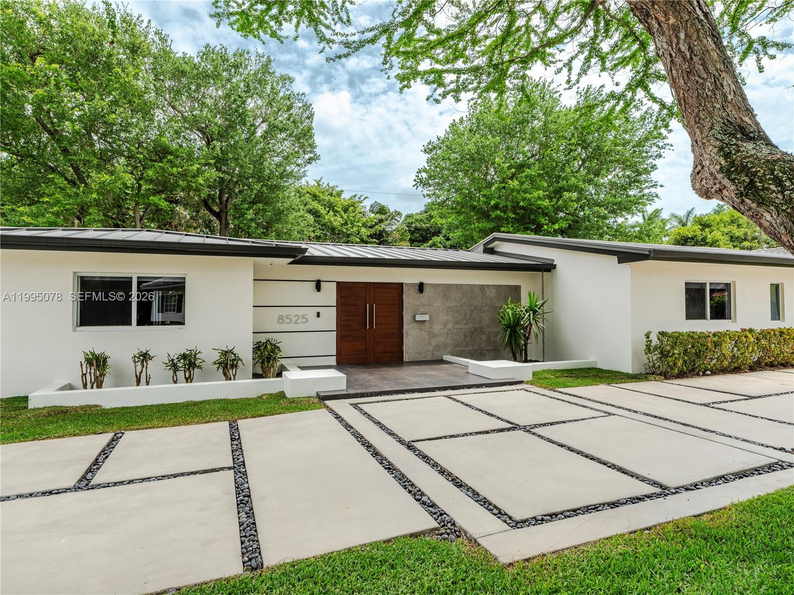 Completely rebuilt in 2017 (construction permits available), this exceptional residence provides 3374 SF of indoor & covered outdoor areas. Every major system and finish has been thoughtfully upgraded, creating a turnkey home designed for both comfort and style. The renovation included electrical systems (buried utility lines), updated plumbing (removed cast iron pipes). Interior and exterior improvements include reconfigured hurricane resistant windows and doors, framing & drywall, interior doors, bathrooms, flooring. The kitchen and baths showcase modern cabinetry, countertops, and appliances. A metal roof with gutters throughout, while mechanical systems were upgraded to include two-zone air conditioning, ducts, and tankless water heaters for optimal efficiency and comfort.Designed with outdoor living in mind, the property features a resort-style heated and cooled pool, along with a custom pergola complete with ceiling fans and a built-in sound system—perfect for entertaining year-round. The lush landscaping includes a fully irrigated yard with three sprinkler zones, a dedicated children’s play area, and a mature podocarpus hedge providing privacy and greenery. Five mature trees, including three stately oaks, further enhance the property’s natural beauty and shade. This is a rare opportunity to own a home, on a 15,600 SF lot, that offers the character of a classic build with the systems, finishes, and lifestyle of a much newer residence.