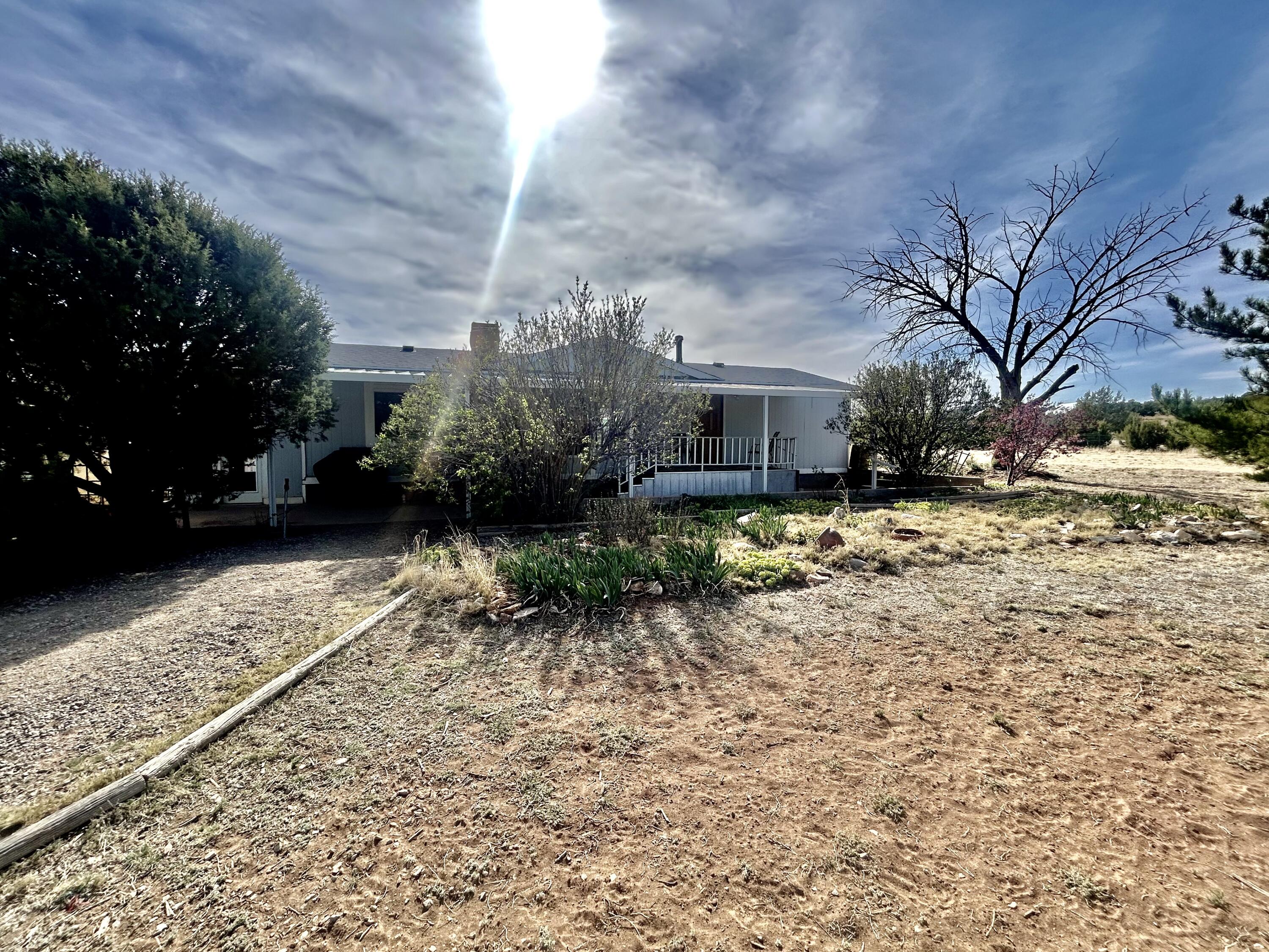Welcome to the east mountains Located just minutes from Edgewood NM.   2 bedroom with an office.  large 2 car garage. Beautifully landscaped home featuring 2 master suites, laminate flooring, cozy wood stove, and covered front deck.  Property is completely fenced... Newer roof.