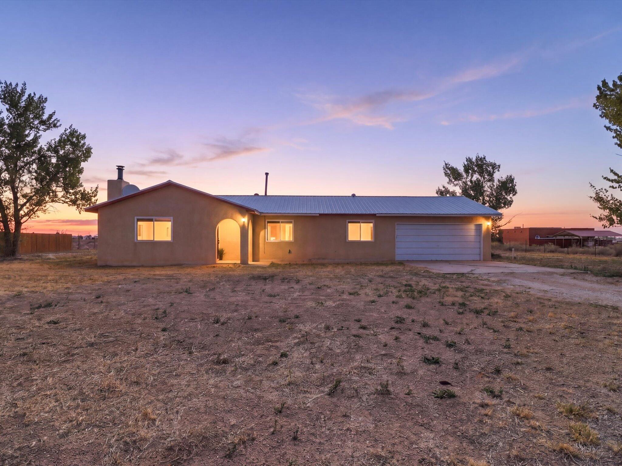 MUST SEE AFFORDABLE DREAM HOME. Experience peaceful country living on the quiet outskirts of Moriarty in this securely-gated property set on 2.2 level acres. This well-maintained home offers two bedrooms with a flexible bonus room that can serve as a third bedroom, second living area, office, or dining space. Pride of ownership is evident throughout with quality upgrades and no corners cut. Improvements include a 2019 septic system and water heater, 2020 high-end Brant refrigerated air and furnace, fresh neutral paint, a renovated main bath, and a resurfaced fireplace with new wood-burning stove. An expensive large steel workshop/hay storage/carport structure was added in 2022, enhancing functionality and value. You owe it to yourself to come tour this magnificent home today...