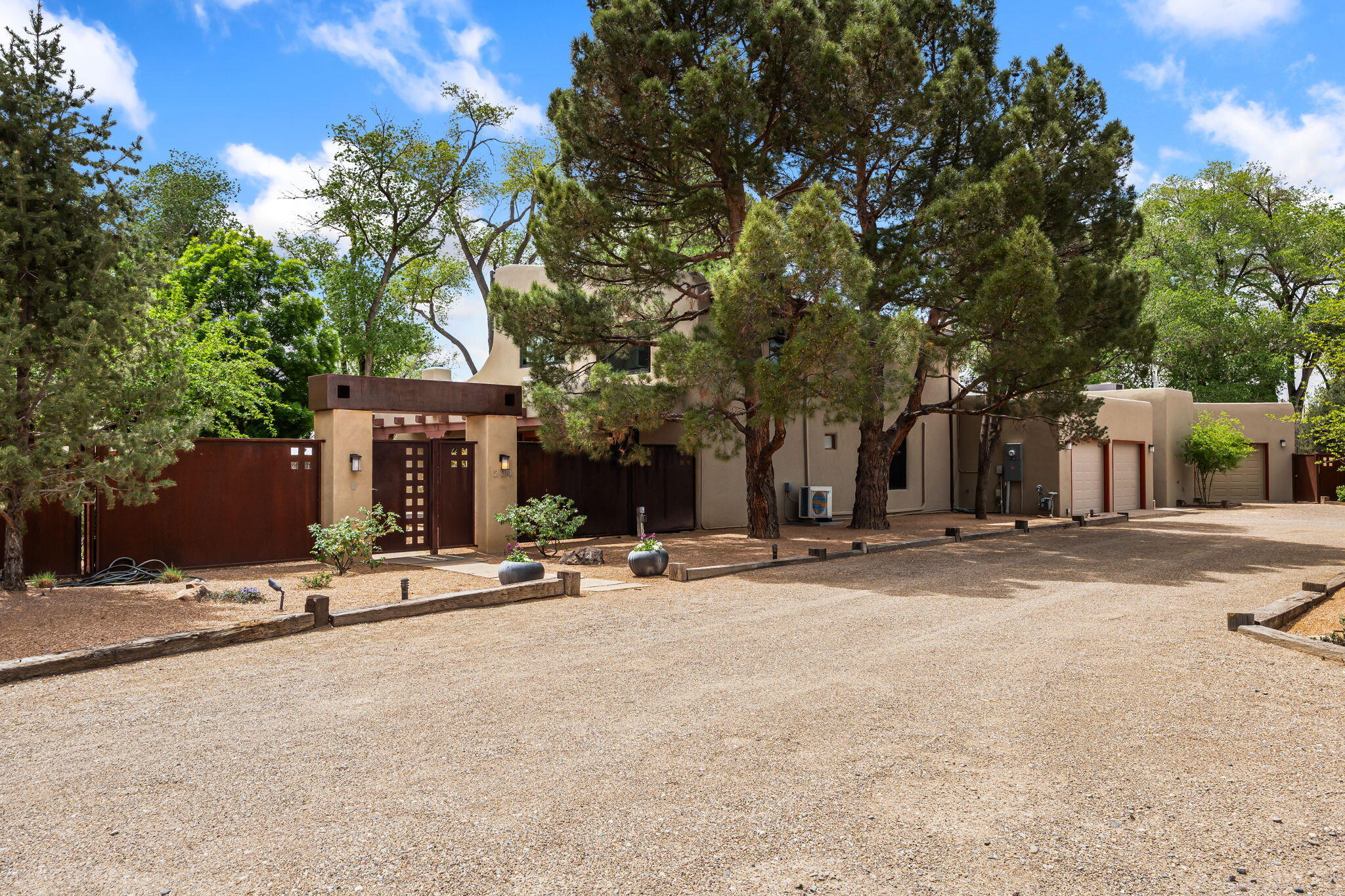Stunning North Valley property. Gated home on .7 acres and conveniently located to everything you could need. The warm adobe walls, kiva fire places, wood beam ceilings and brick floors create a beautiful environment that gives you a traditional NM feel! Recent updates include; synthetic stucco, wood clad windows, motorized blinds, mini splits throughout, water softener, metal roof on main floor, full kitchen remodel, guest bathroom updates and much more! The outdoor space is paradise. Walk out to lush grass, trees, multiple seating areas, gunite pool with hot tub and water slide, outdoor kitchen, built in fire pit and sound system. Enjoy the pool house area with kitchen amenities and bathrooms. One of a kind property that has been loved and updated over the years. Must see in person!