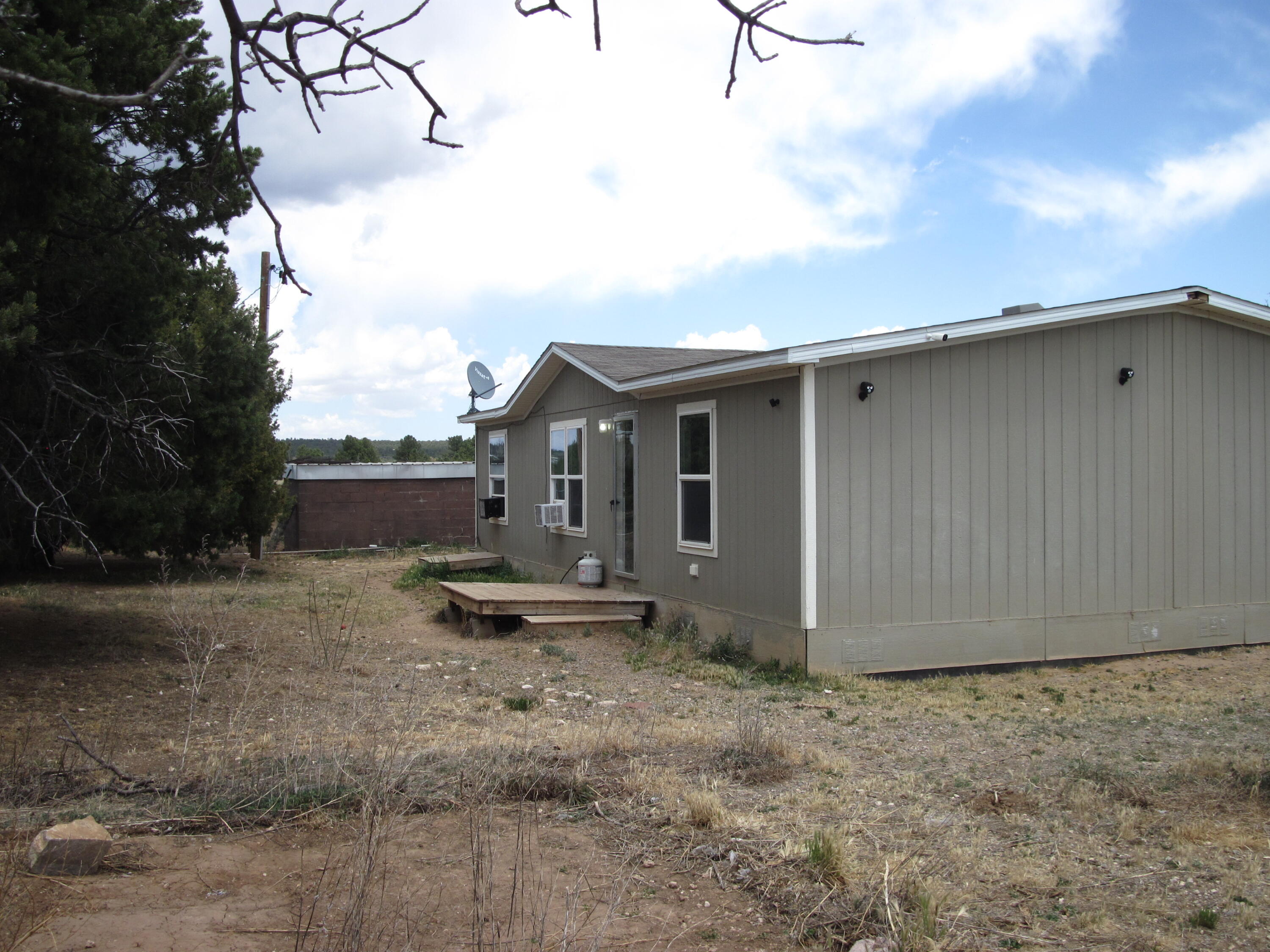 Manufactured 3 bedroom, 2 full bathroom home. Split, open floorplan with large garden tub and walk-in closet in the master. Open living, dining and kitchen area maximizes space. Stunning property with 360 views, yet level 2.91 acre pasture for horses. Fully fenced. and gated plus a concrete patio, now a dog kennel. Great space for building a barn, shop or whatever your heart desires. 2x6 construction. Affordable country living. Is a water haul area with 3,200 gallon water storage and trailer with mobile tank stays.