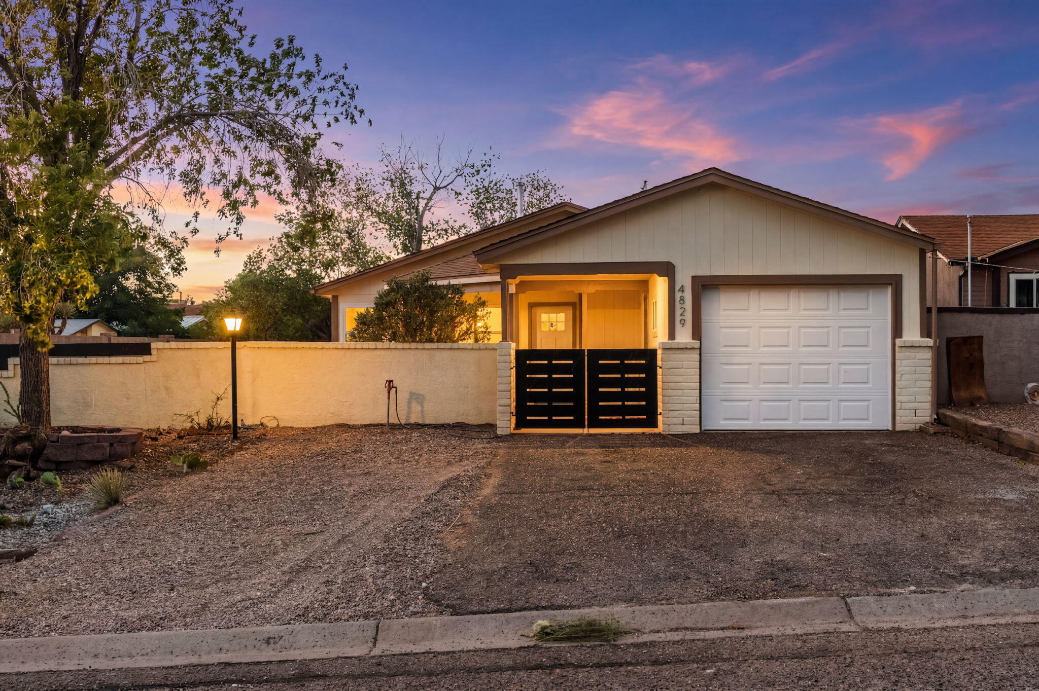Beautifully updated home on an oversized corner lot with spacious, walled front and back yards. Enjoy outdoor living with a covered front porch, open back patio, and potential side yard access. Inside, the open floor plan features new laminate flooring, recessed lighting, and ceiling fans throughout. The fully remodeled kitchen showcases brand-new cabinetry, quartz countertops, stainless steel appliances, and a countertop with seating, creating a functional space for everyday living and entertaining. The primary suite includes an ensuite bathroom with a shower. Additional upgrades include a new shingle roof, new windows, and a new refrigerated air combo unit. This move-in ready home offers modern finishes, thoughtful updates, and plenty of space to enjoy both inside and out.
