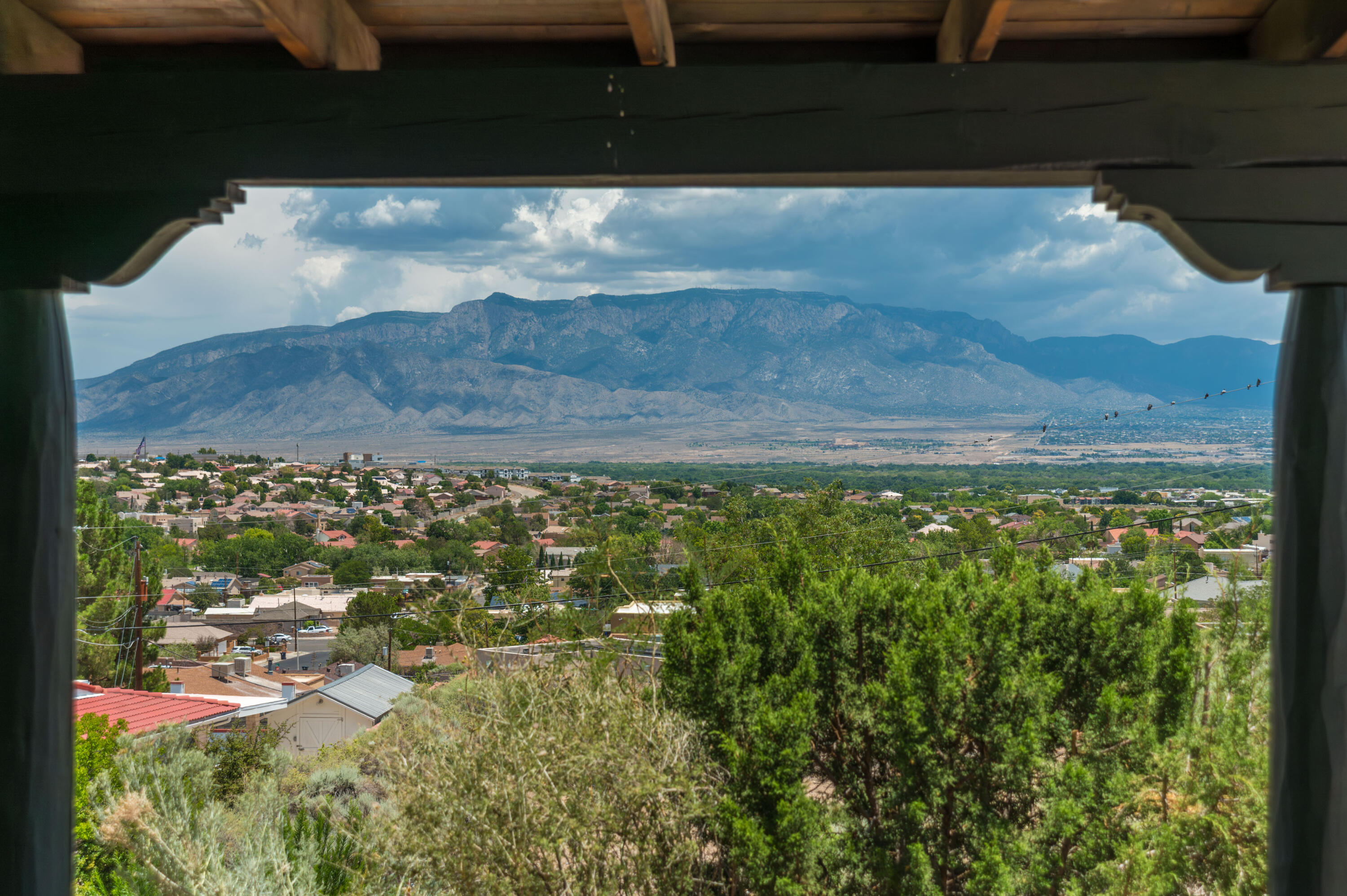 VIEWS*VIEWS*VIEWS* This Custom-Built SW Pueblo Style GEM offers spectacular 180 degree views of the mountains and city lights. The patio runs the full length of the front of the home with sliding glass doors opening from the kitchen, living room, dining room, owners suite & sunroom onto the patio. Don't miss a sunrise, sunset reflecting on the mtns, Balloon Fiesta Mass Ascension or Glow. Remodeled kitchen features handmade solid walnut cabinets! Quartz counter, stainless appliances* dual pantry, coffee bar*beverage fridge & of course those views. Primary bath is also remodeled and updated with custom cabinetry, shower, bathtub, lighting and sinks. Tile & Laminate flooring & there is a sunroom off the primary perfect for exercise room + Hall bath is also remodeled* Recent master cool a 10+