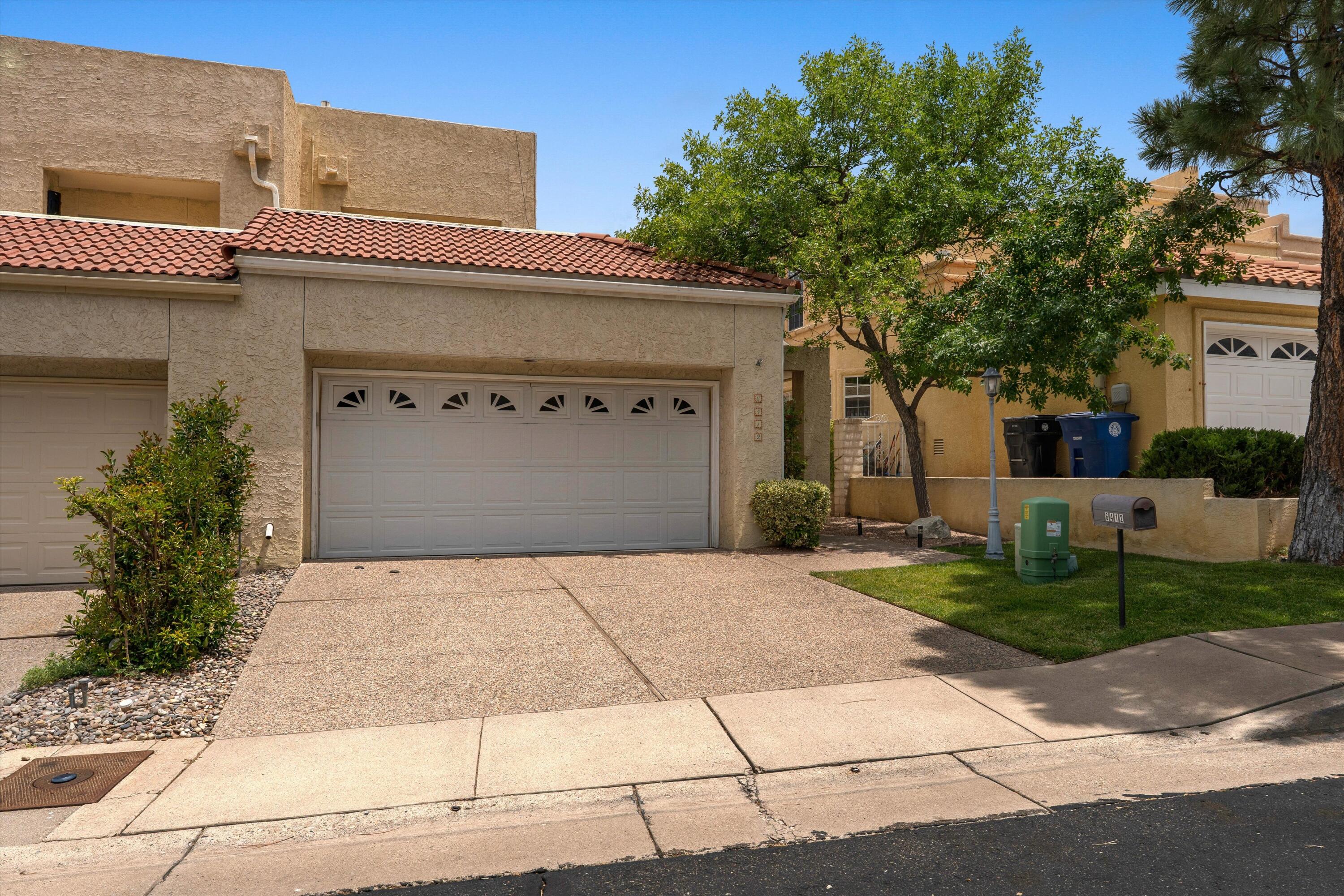 Welcome to this stunning 3-bedroom, 2.5-bathroom home located in the prestigious, guard-gated golf community of Tanoan, featuring 24/7 live-person managed access for ultimate peace of mind and situated within the highly coveted La Cueva school district. Designed with comfort and style in mind, this light-filled residence boasts soaring ceilings, skylights, newer high-efficiency windows, and elegant shutter blinds throughout. The main level features a desirable downstairs primary bedroom complete with a luxurious floor-to-ceiling tiled primary bath, a cozy wood-burning fireplace in the living area, refrigerated air, and a fully equipped kitchen with all appliances included. Upstairs, you will find additional bedrooms featuring custom closet shelving and a large balcony that is perfect for taking in the beautiful New Mexico weather. Complete with beautifully landscaped front and back yards, this exceptional property offers the ultimate blend of security, convenience, and upscale living.
