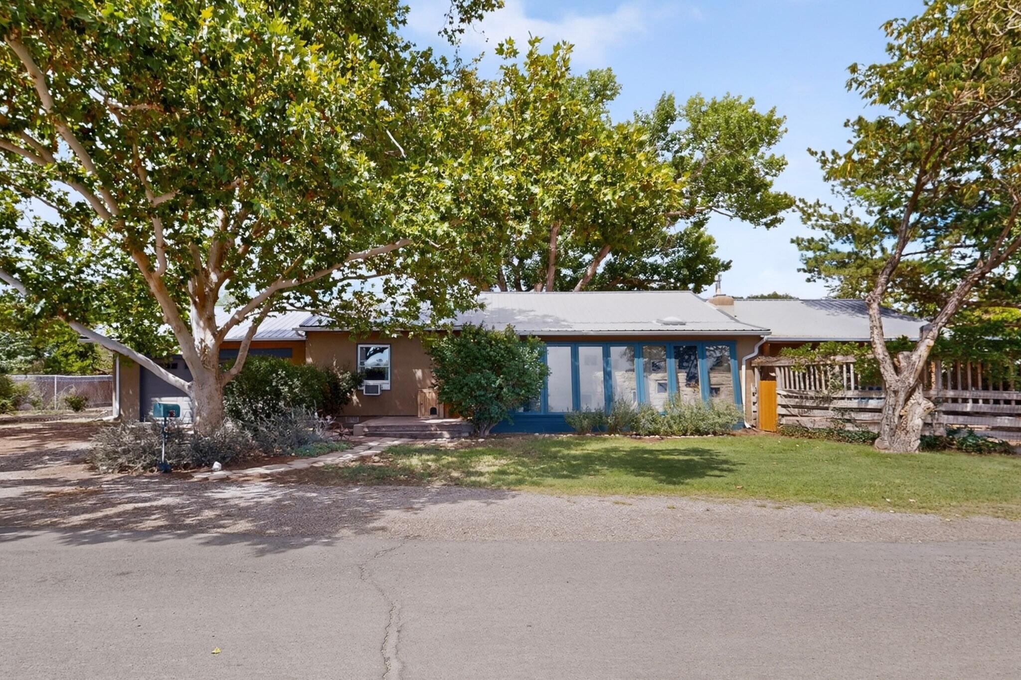 Highly sought-after oasis in the North Valley!  Welcome to this uniquely crafted Old World SW style home nestled in the valley just minutes from the Balloon Fiesta grounds and the Rio Grande Bosque. You'll be captivated by its artistic charm from the moment you enter!  Brick floors throughout, passive solar and two gas fireplaces create comforting warmth.  Master craftsman woodwork, adobe accents, and vaulted ceilings are just a few custom features creating the artistic vibe.  Separate bedrooms, a cozy office, and a spacious recreation/flex room with a pool table make this home perfect for quiet relaxation or entertaining guests.  The inspiring kitchen features custom walnut cabinetry and opens to the den and breakfast nook that looks out into the tranquil setting of the back yard.  Step outside into your private sanctuary: lush, mature trees, wrap-around brick patio, and large winding pond with waterfalls create a perfectly peaceful escape from the hustle and bustle.  Various sitting areas, an outdoor fireplace, a large storage shed, 240V EV Charge Point j11772, and an irrigation well add to this property's functionality and serene setting. This property, in the northern corner of the north valley feels far away, yet close to everything.