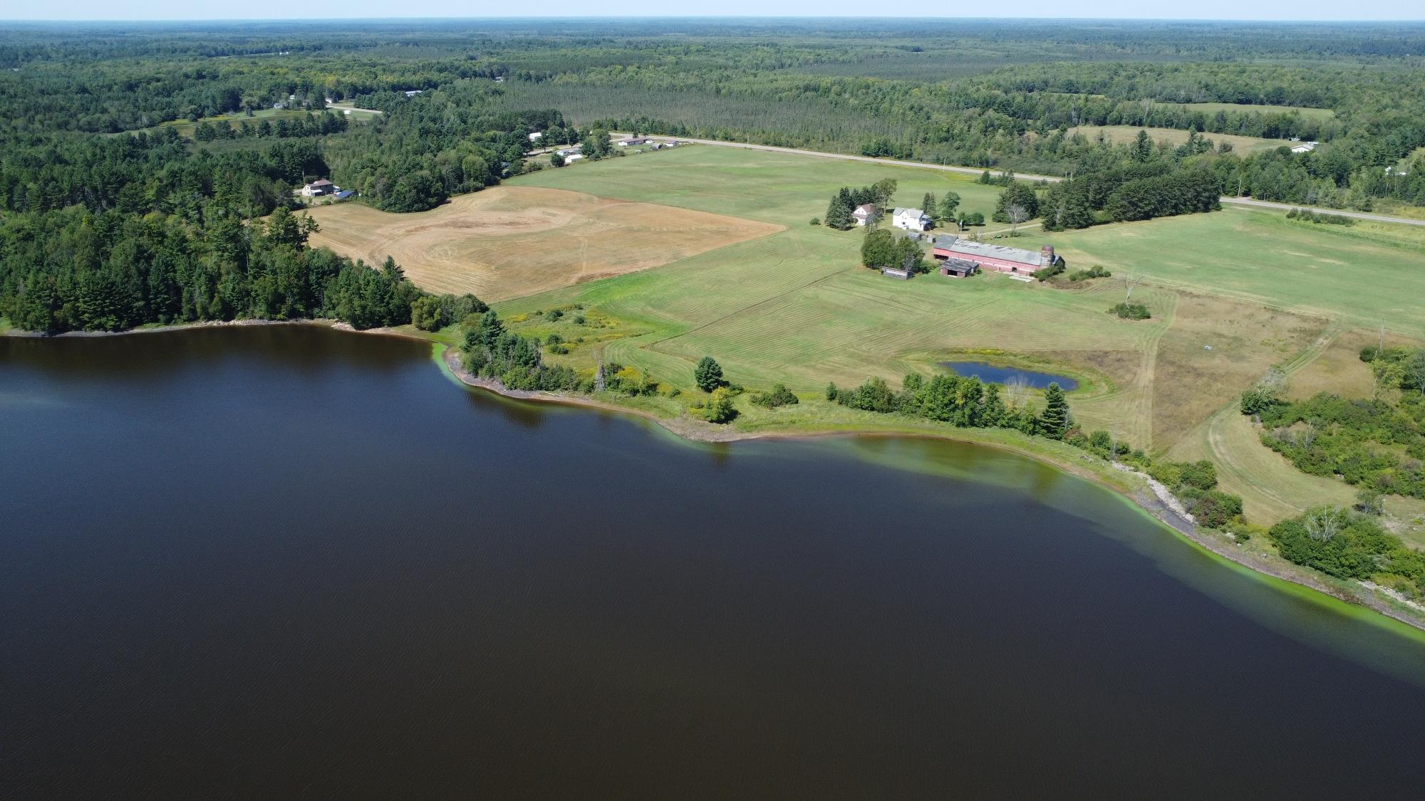 Discover the possibilities offered by this versatile 37-acre parcel on the Spirit Flowage! The property features two homes, multiple outbuildings, and endless potential for use as a hobby farm, private retreat, or future development opportunity. The first home offers two bedrooms, one full bath, a screened porch, and a detached 16' x 24' garage with a lean-to. The second home features six bedrooms, one full bath, an additional toilet in the primary bedroom, and a screened porch. Both homes need significant work and are not currently livable; however, with the right improvements, they could become valuable assets to the property. Outbuildings include a substantial 36' x 152' hay barn with milking stalls below, a 30' x 36' tractor shed, a 14' x 30' chicken coop. With abundant acreage, a desirable location on the Spirit Flowage, multiple structures, and extensive agricultural buildings, this unique property is ready for your vision. Bring your ideas and don’t let this opportunity pass you by! All Data approximate, Buyer to verify all information. W7011 Hwy 86 is included.
