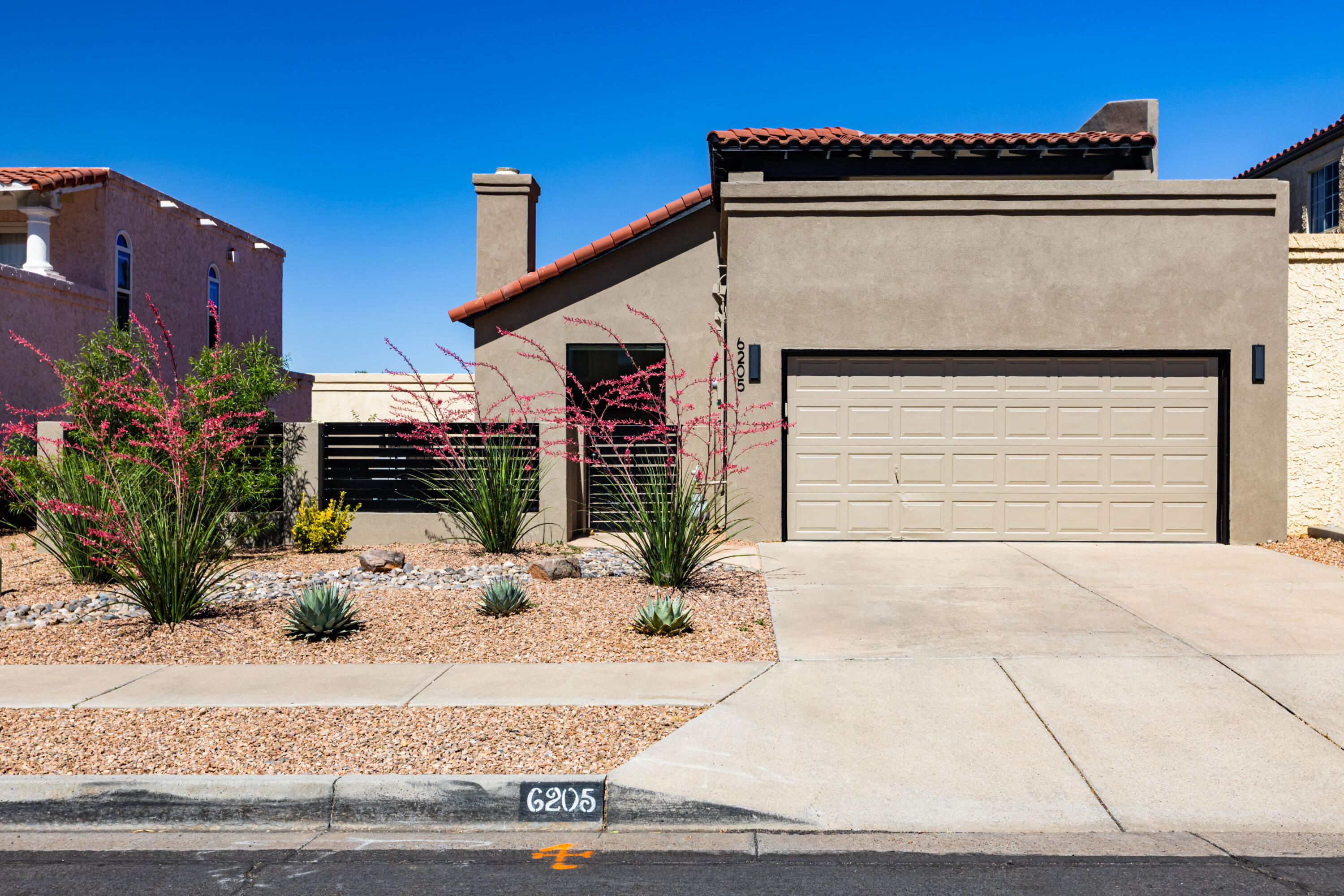 Experience this stunning contemporary remodeled beauty in this highly desired far NE Heights location. You will not find another home so tastefully redone, with breathtaking mountain views from the front courtyard and the upstairs deck and owner suite. This easy-living open design is filled with natural light, tile and wood floors throughout.  Stunning slabs of quartzite and designer tile create a true one-of-a kind home. The bright kitchen offers new cabinets, new upgraded appliances and a gorgeous limestone accent wall. Both bathrooms are updated, and a large flagstone patio area is perfect for a fire pit, entertaining, or simply taking in the spectacular mountain views. Two bedrooms are downstairs and share a stunning walk-in shower. The upstairs is a true sanctuary with a huge walk-in closet, a dream bathroom completely remodeled, and a rooftop deck to experience morning sunrises and evening sunsets with the Sandia mountains as a backdrop. Other updates include all new plumbing fixtures, lighting, interior doors, contemporary stair railings, garage epoxy flooring, TPO roof over garage and kitchen, and more.  Once you see this home, you will know this is where you belong!