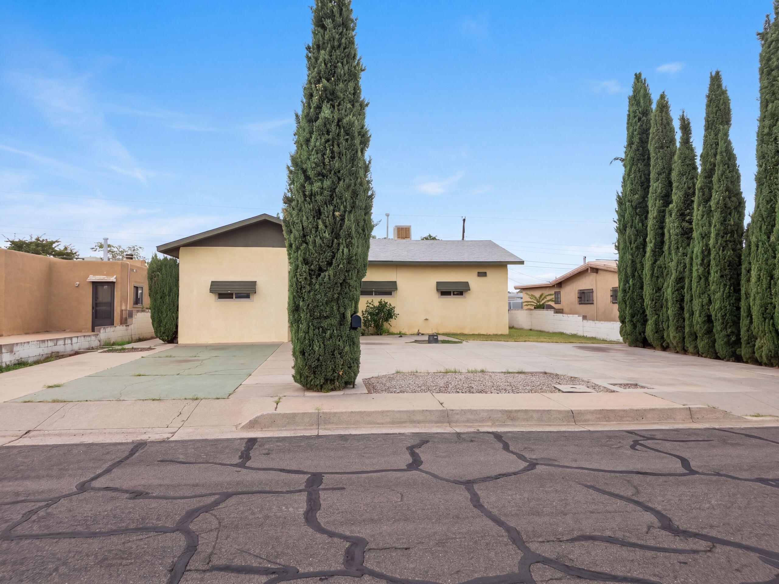 9222 Aztec Rd NE is a one-story Albuquerque home with 3 bedrooms, 2 bathrooms, and 1,265 square feet of living area. Built in 1955, the home includes a kitchen with extensive cabinetry and counter space, an adjoining dining area, and a living room with a freestanding fireplace. The bedrooms are arranged on one level, and the two bathrooms include both tub and shower configurations. A utility area provides added household function, while the enclosed yard and driveway extend the usable exterior space. The layout separates the main gathering areas from the bedrooms for straightforward daily living. Included 100-Day Home Warranty with buyer activation