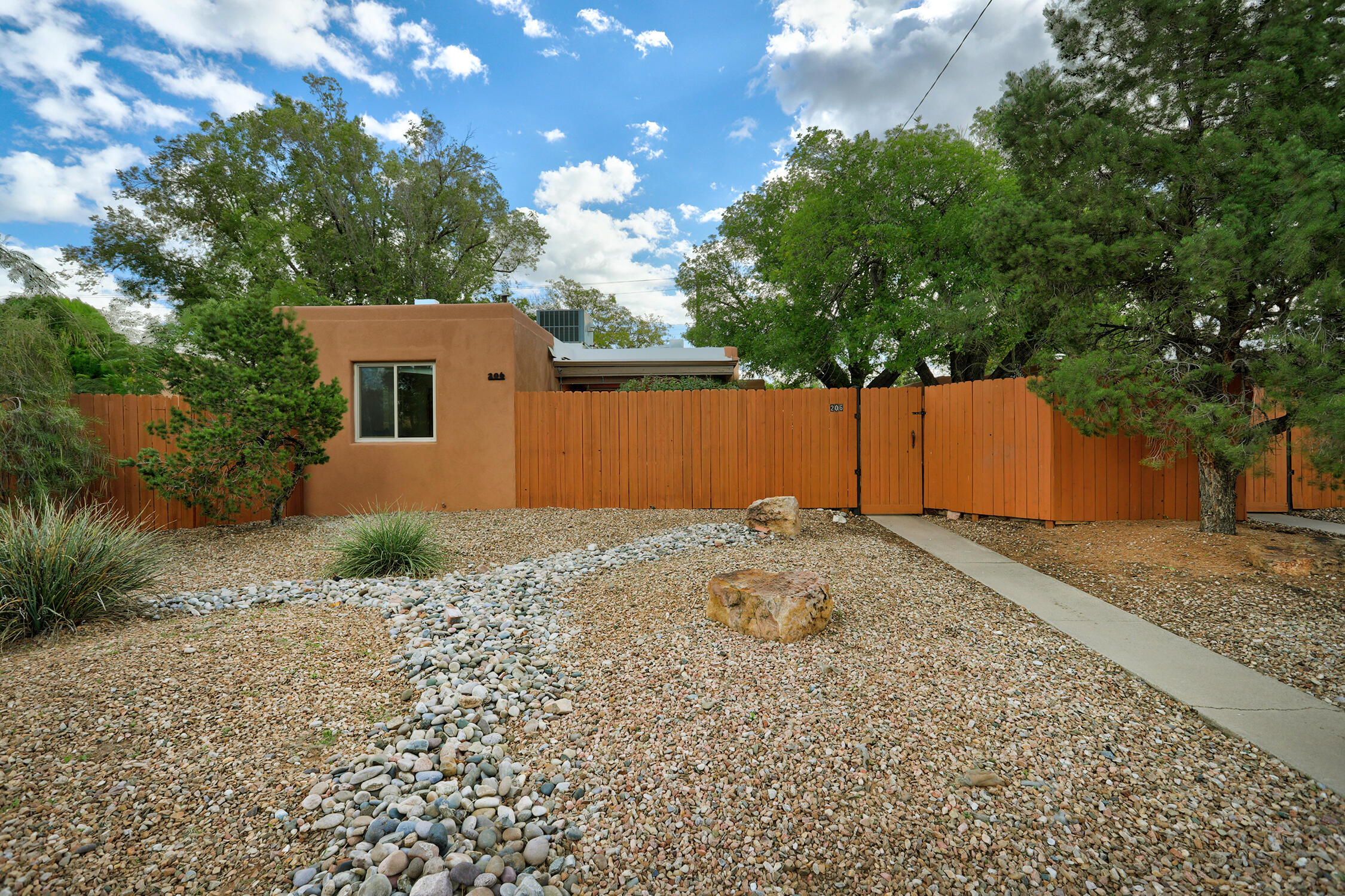 Live in one and rent the other three or have multigenerational living! An opportunity for owner-occupied multi-unit living in Albuquerque's desirable UNM North neighborhood near Nob Hill. This charming, updated 1950s 4-plex offers a vacant 2-bedroom residence ready for its new owner, plus three additional units with long-term tenants providing rental income potential. Originally two duplexes on separate lots, now replated as one property, the four residences include two 1-bedroom and two 2-bedroom units. Each offers original oak hardwood floors, granite countertops, refrigerated air, tankless water heater, individually metered gas & electric, and its own washer & dryer. Every residence enjoys a private backyard and garage, plus additional off-street parking with two double carports and gated alley access. At the center of the property, an enchanting, tree-shaded courtyard with lush grass and inviting seating areas creates a peaceful gathering place and wonderful sense of community while preserving each residence's privacy. Enjoy living near UNM, Nob Hill, Uptown, shopping, restaurants, and public transportation. With four units, this property may qualify for FHA or conventional owner-occupied financing, subject to lender and property requirements. A unique opportunity to enjoy the character of an established Albuquerque neighborhood while building equity through real estate! Address is both 204 & 206 Monroe St NE