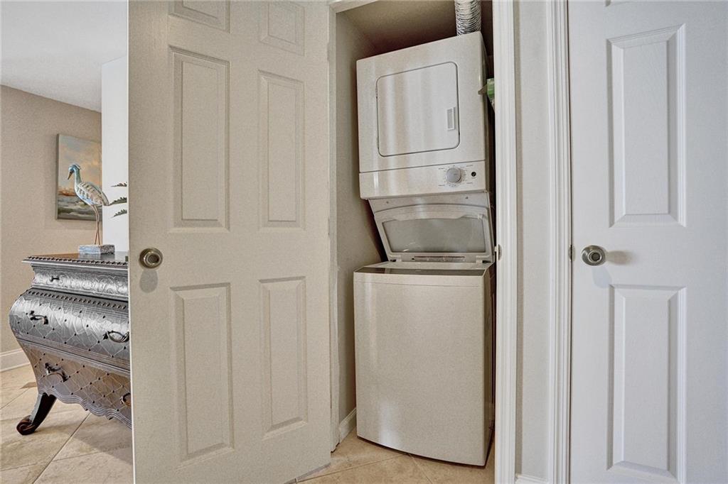 The washing machine and dryer is located in one of the two entry way closets.