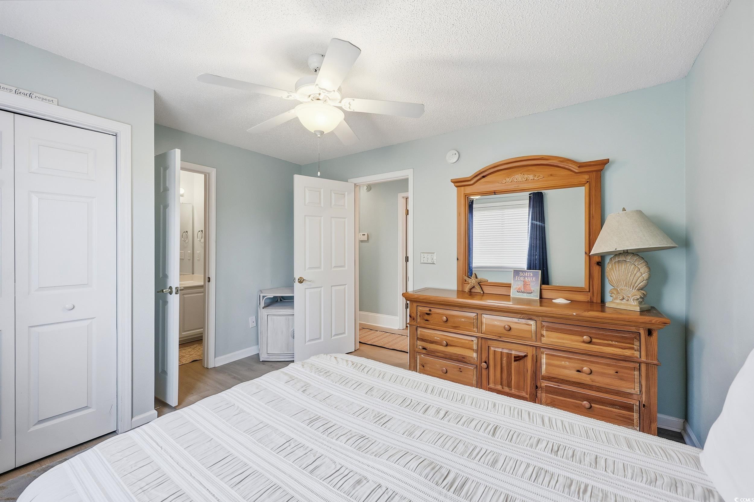 Bedroom featuring a closet, ceiling fan, connected bathroom, and a textured ceiling