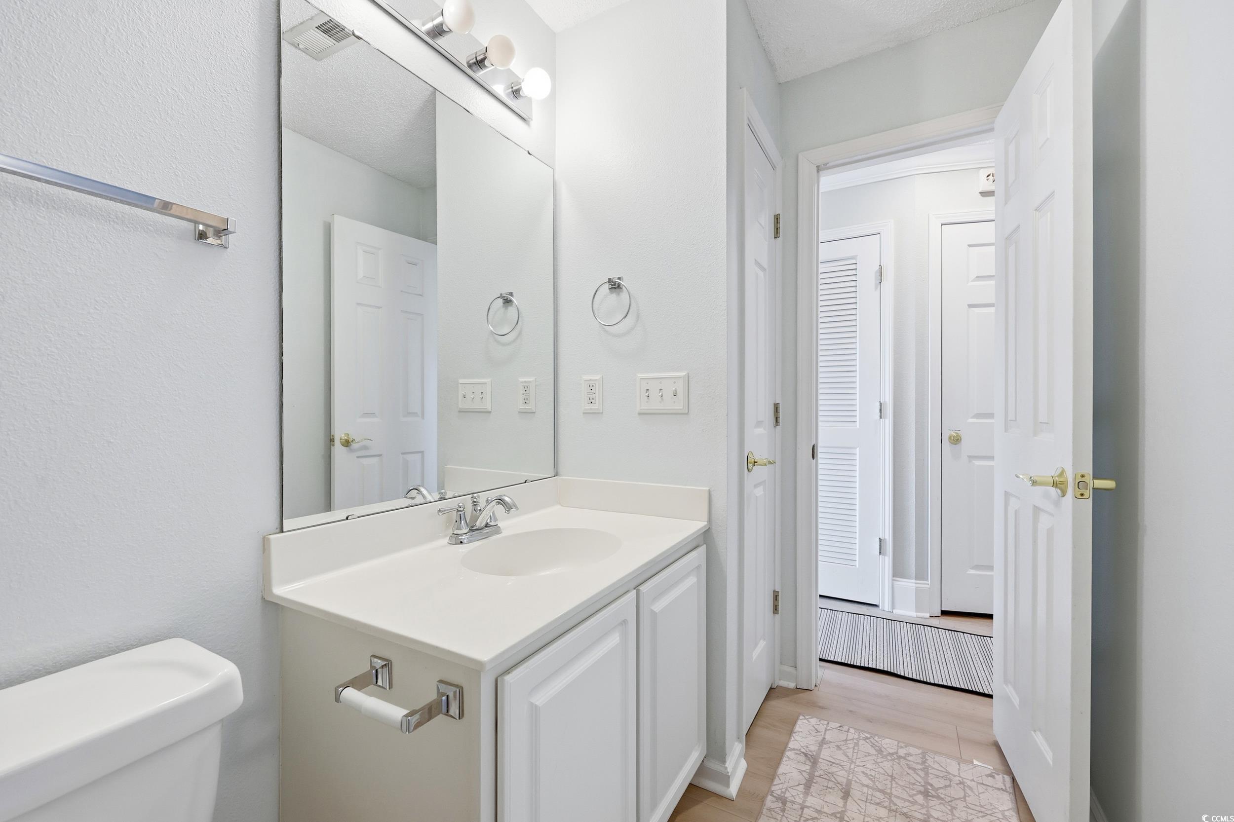 Bathroom with vanity and a textured wall