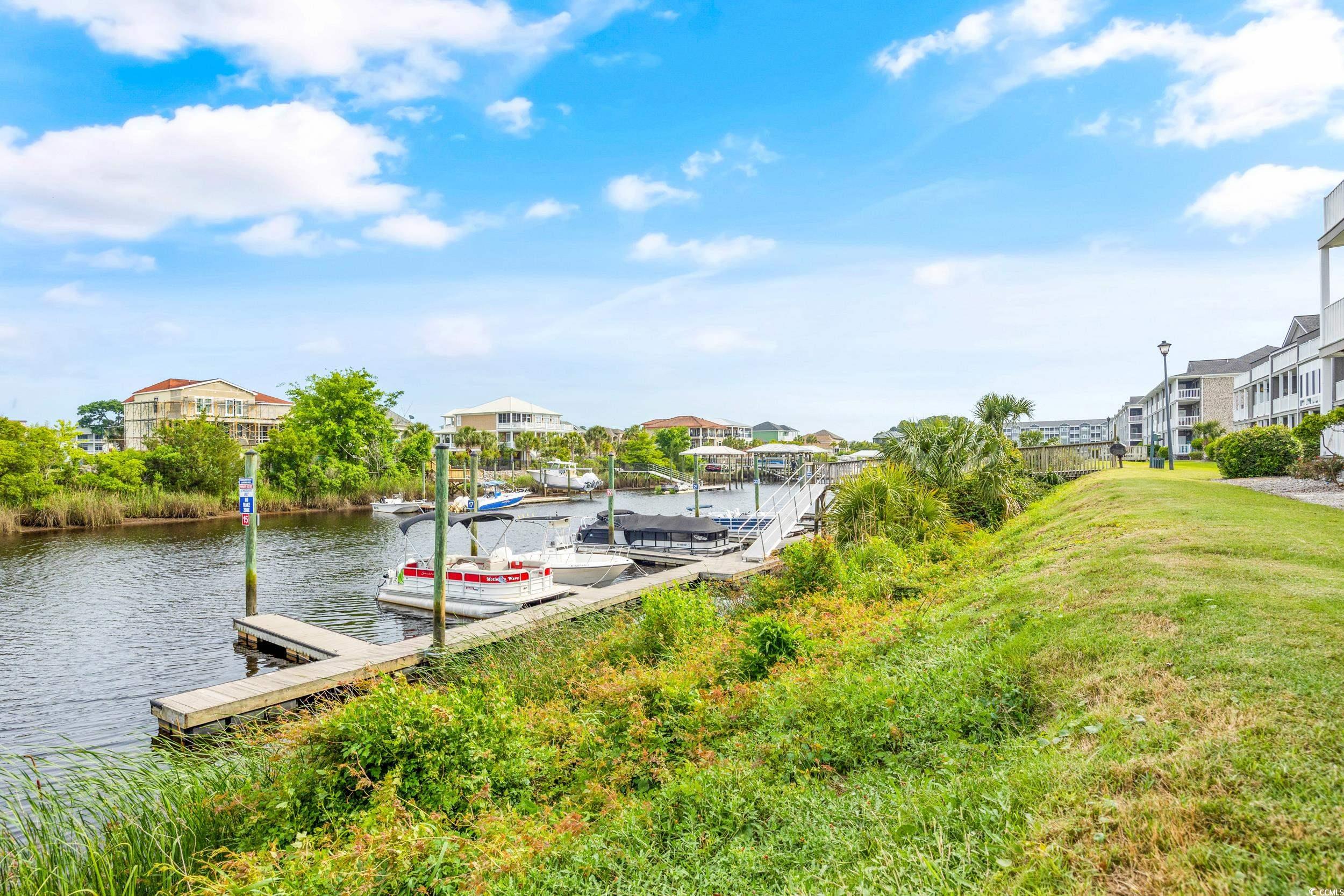 Dock featuring a water view, a residential view, and a lawn