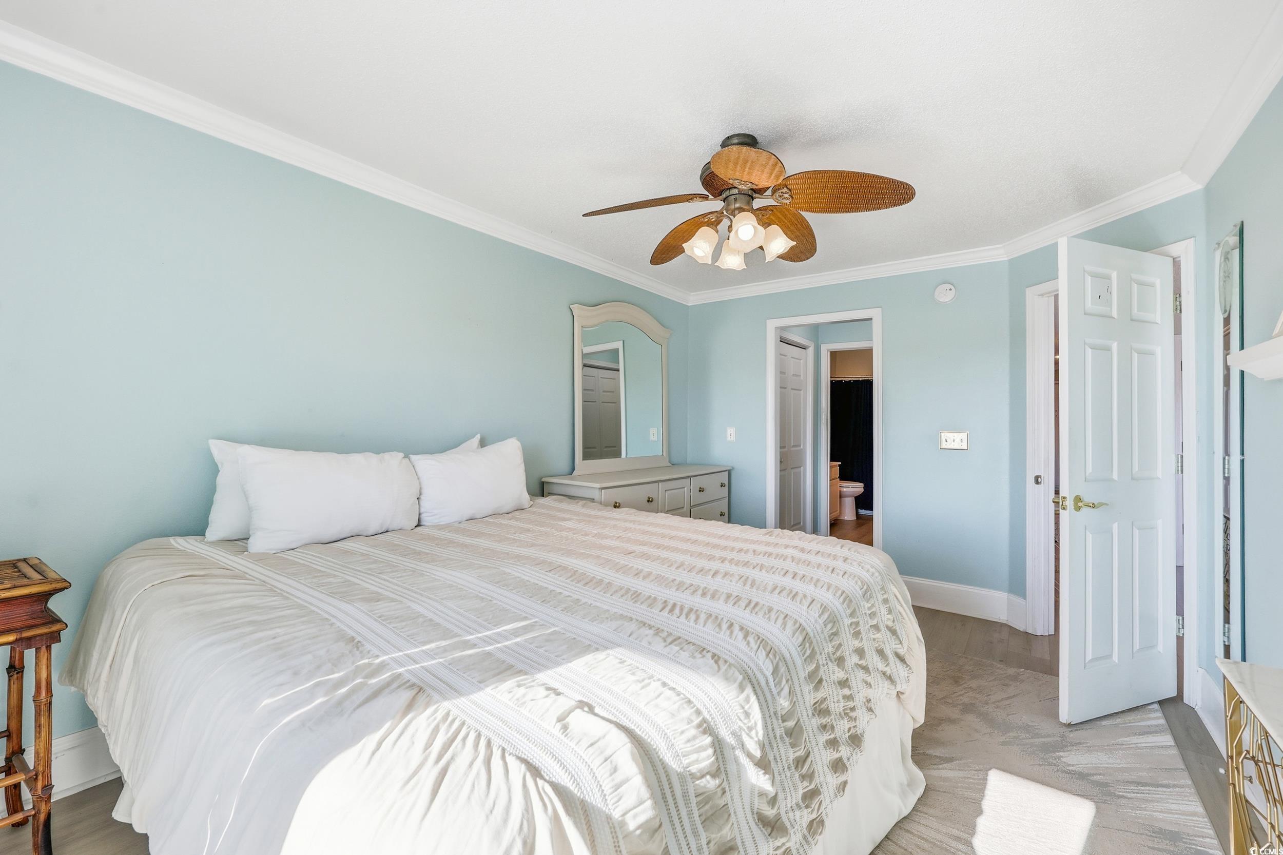 Bedroom featuring crown molding, ceiling fan, and light wood-type flooring