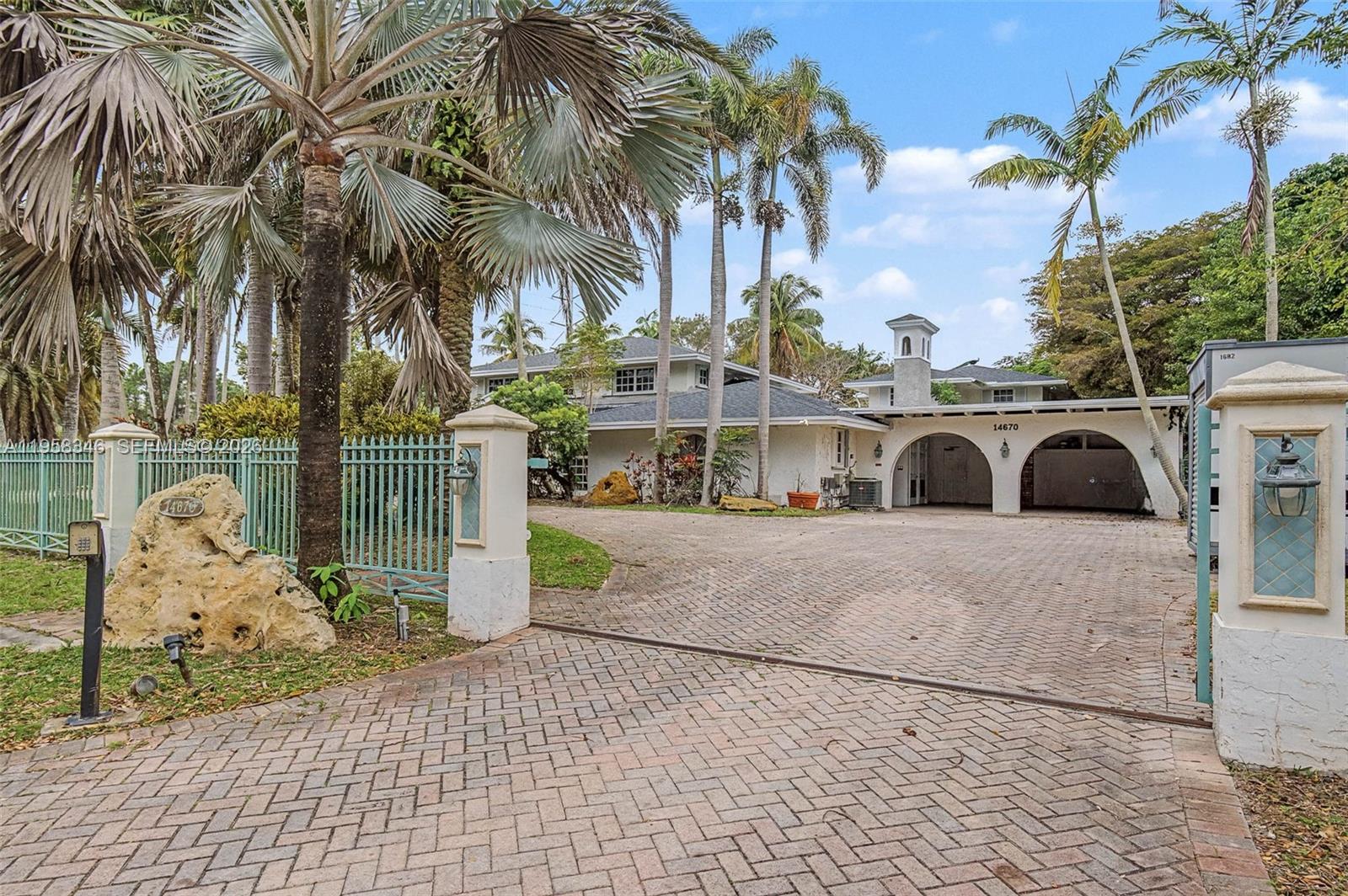 Exceptional opportunity to own an expansive, 9 bdrm/ 7 bath, 2 story estate on nearly an acre, gated and fenced property, with endless potential in Northeast Palmetto Bay. Formal living and dining rooms. Spacious kitchen with center island & walk in pantries, opens to grand family room. Sunroom. Primary suite located on the first floor, features double closets, large bath. Laundry room with sink, cabinetry and folding area. Additional living area with wet bar, butler's pantry, office. Spectacular, lush backyard with mature trees and tropical plants, tiled patio, built in BBQ, koi pond, grotto/fountain, gazebo, half basketball court, shed. Circular paver driveway. 2 car garage