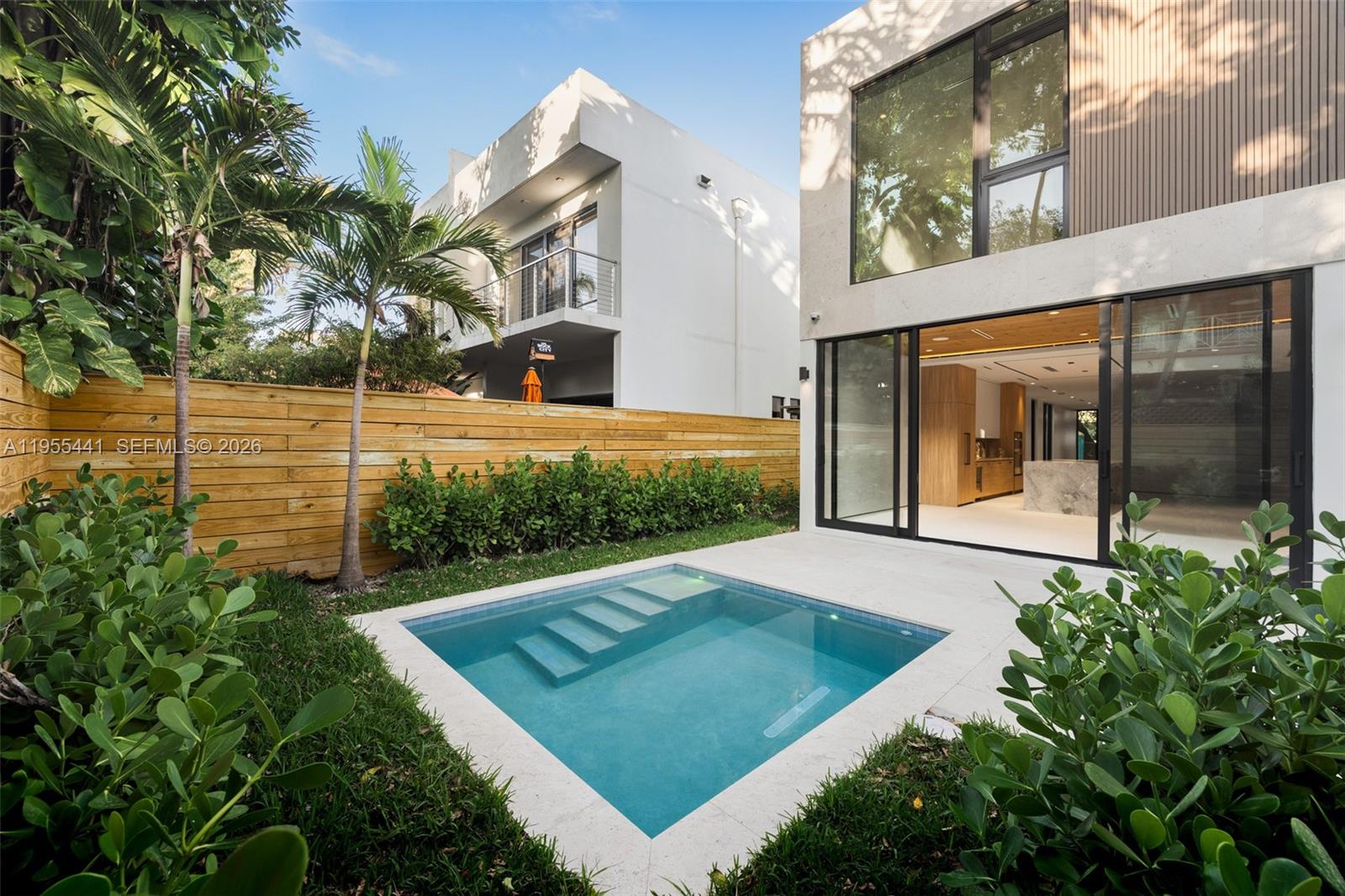 A striking new construction in Coconut Grove, blending contemporary design with timeless comfort. This 4BD+den, 5BA residence offers an open layout with coral stone flooring on the main level and engineered wood upstairs. Soaring ceilings, 9' solid wood doors, and floor-to-ceiling impact glass create a seamless connection to the outdoors. The chef's kitchen features quartzite counters, built-in appliances, and a sleek induction range with downdraft ventilation. A staircase with tempered glass railing leads to a spacious upper-level primary suite with walk-in closet and spa-style bath. Enjoy integrated sound systems, security cameras, and wiring for motorized shades throughout. The lushly landscaped backyard includes a pool and a built-in summer kitchen ideal for entertaining. Conveniently located near the Grove’s village center, parks, and top schools, this home offers sophisticated living in one of Miami’s most coveted neighborhoods.