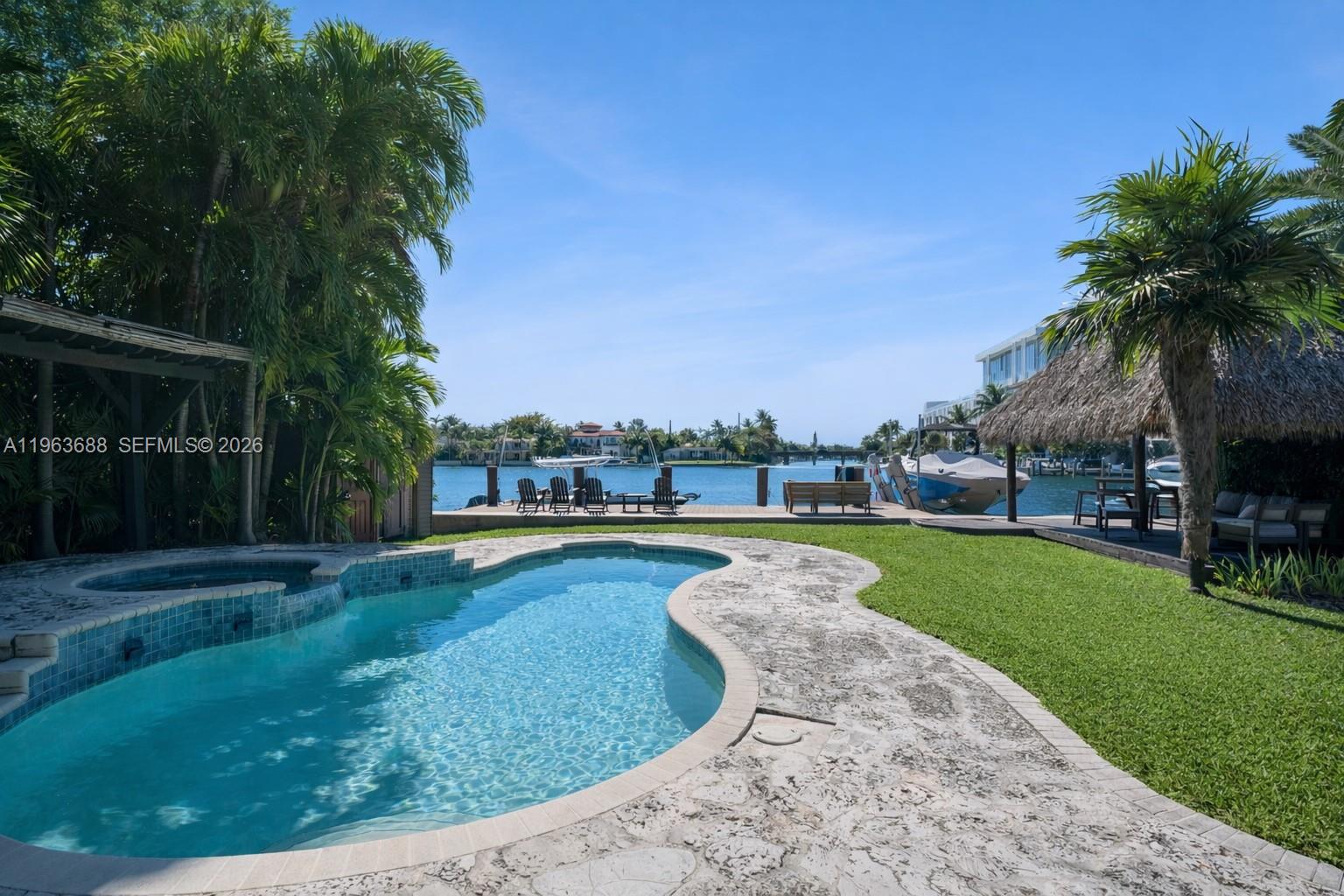 Situated on the widest stretch of Surprise Lake in the heart of Lakeview, this oversized 14,140 SF waterfront property offers expansive open water views, direct ocean access, a private dock, pool, and expansive backyard designed for boating, entertaining, and everyday outdoor living, a true boater’s paradise.The four-bedroom residence features bright interiors with strong natural light, well-proportioned bedrooms, and comfortable living spaces that open seamlessly to the water. Large windows and effortless indoor-outdoor flow create an airy, light-filled environment throughout. The primary suite overlooks the lake and features a spacious bathroom, offering a private waterfront retreat. A sunlit kitchen equipped with Wolf appliances anchors the home, opening to comfortable living and dining areas ideal for gatherings and daily family life. The layout supports effortless living today, with the ability to elevate and modernize over time to reflect your own design vision.Lakeview is one of Miami Beach’s most established and desirable neighborhoods, known for tree-lined streets, a strong sense of community, proximity to top schools and parks, and convenient access on and off the Beach. Enjoy the home as is, update to your taste, or design a custom waterfront estate that fully maximizes this exceptional lot and premier location.