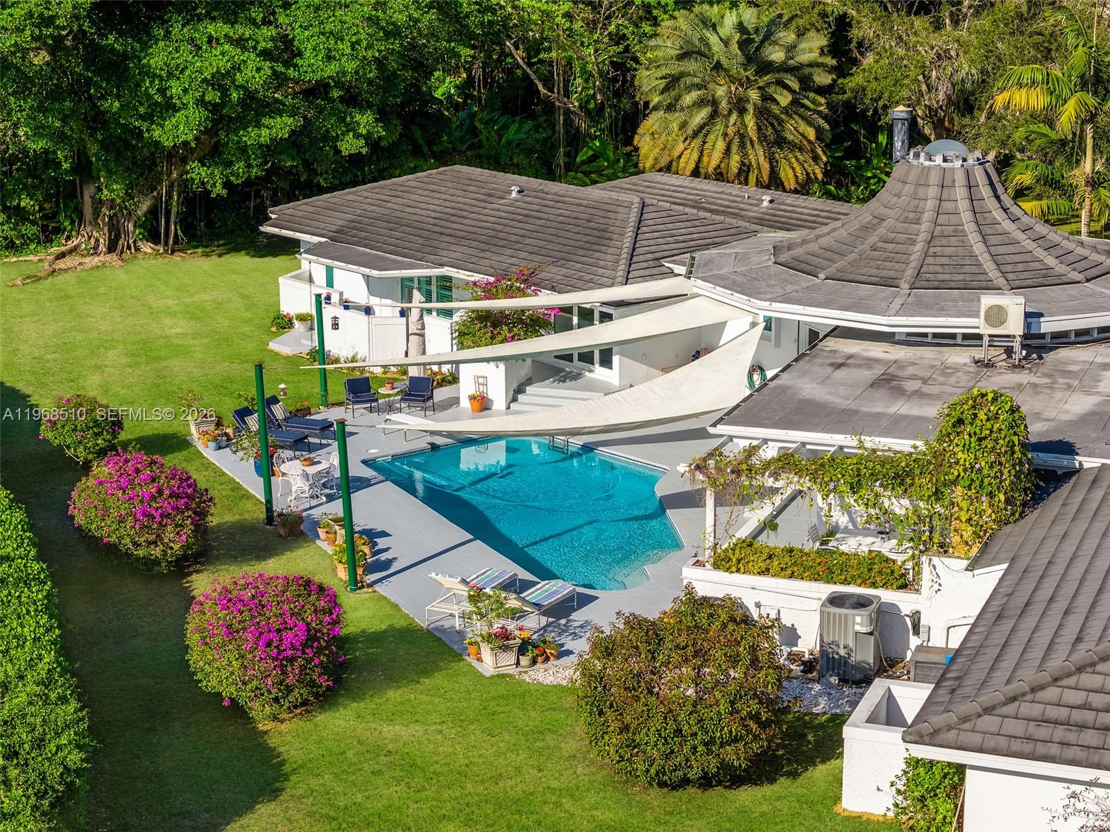 Set on a premier builder’s acre in the heart of Pinecrest, Florida, this striking canal-front estate is a rare blend of architectural pedigree, thoughtful updates, and timeless design. Originally conceived by noted architect Barry Sugerman, the home makes an unforgettable first impression with its dramatic wood rotunda entry, soaring ceilings, and signature curved walls that create a sense of flow and quiet sophistication throughout. Spanning over 5,000 square feet, the residence offers five bedrooms and five baths, including private staff quarters. The interiors have been beautifully refreshed, featuring rich cherry hardwood floors, marble finishes, and custom Italian doors. The chef’s kitchen is both functional and stunning, equipped with double Wolf gas ovens, an oversized Sub-Zero refrigerator, and a generous workspace designed for both everyday living and entertaining. Walls of impact glass open to a resort-style outdoor setting with a sparkling pool, expansive grounds, and tranquil canal views, enhancing the home’s sense of privacy and scale. A three-car garage, newer roof, and location within Pinecrest’s top-rated school district further elevate the offering. This is a home for those who appreciate architecture, space, and one of Pinecrest’s most desirable waterfront settings. An exceptional opportunity to own a truly distinctive property.