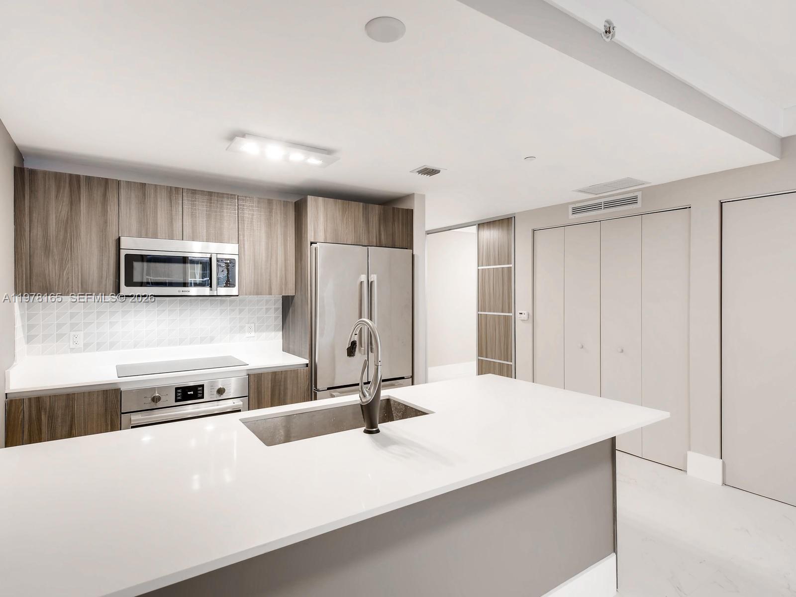 Looking for an Edgewater condo with bay views, flexible space, and built-in rental income? This residence at Aria on the Bay offers bright open living, a versatile den ideal for a home office or guest area, and a spacious balcony overlooking Biscayne Bay.Positioned in the heart of Edgewater, Aria on the Bay is known for its waterfront setting and full-service lifestyle. This residence features a functional open layout designed for everyday living and easy entertaining. Floor-to-ceiling windows bring in consistent natural light, while the private balcony offers north-facing views of Biscayne Bay and the Miami skyline, an ideal setting to unwind and take in the city.The layout includes a comfortable living and dining area,  a modern kitchen with sleek cabinetry and stainless appliances. The den adds meaningful flexibility, whether for working from home, hosting guests, or creating a media space. The primary suite offers ample closet space and a well-designed bathroom, with an additional full bath for guests.Residents enjoy resort-style amenities including sunrise and sunset pools facing the bay, a fitness center, yoga studio, spa, theater, social lounges, business center, outdoor BBQ areas, and concierge service. Currently rented through Nov 2026 at $3,300/month, offering immediate income and stability for investors.Well-positioned in today’s market, this unit stands out among Edgewater options for buyers prioritizing income, flexibility, and long-term value.